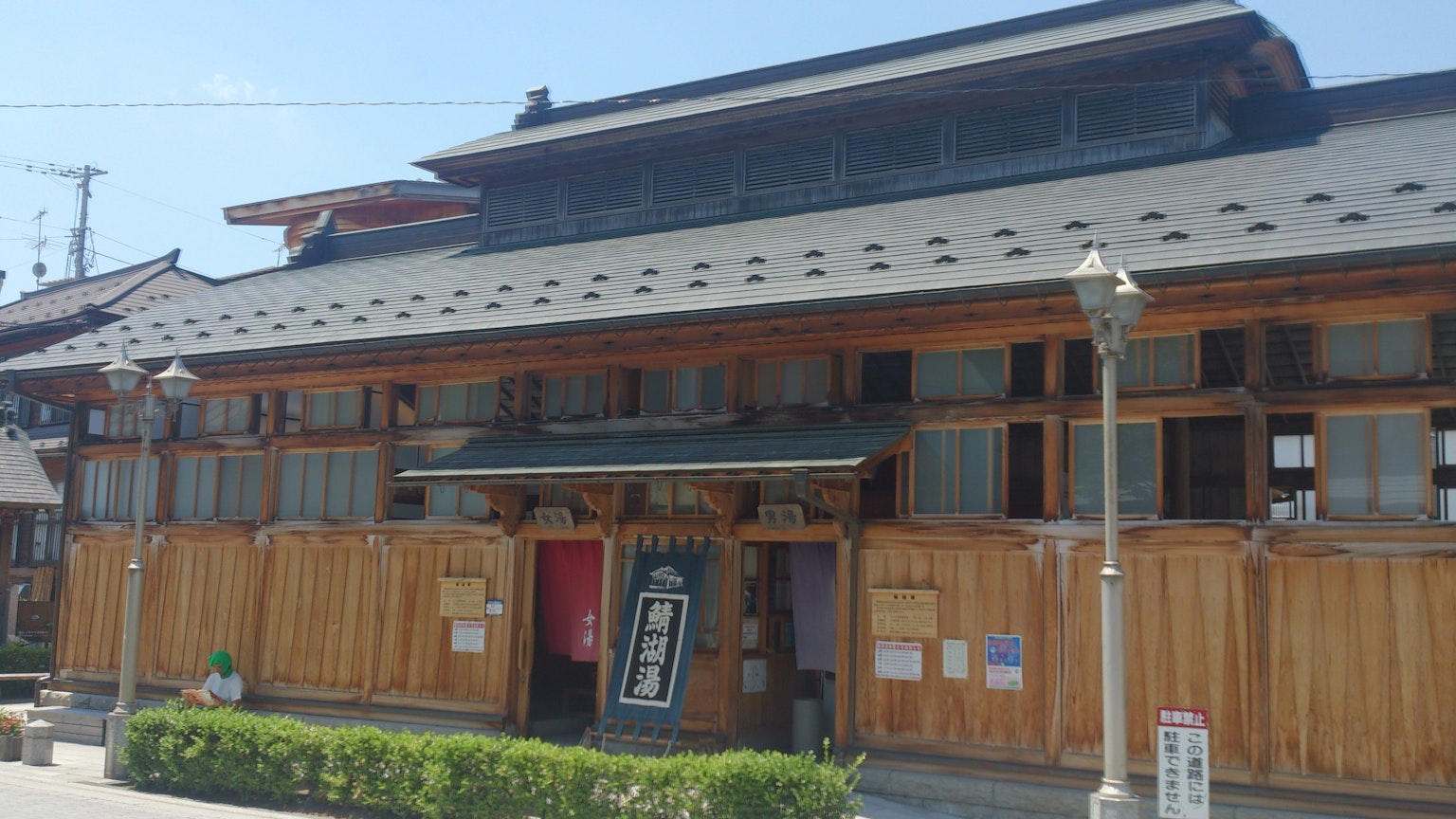 Extérieur d'un bâtiment en bois japonais traditionnel avec un aménagement paysager vert et un toit décoratif