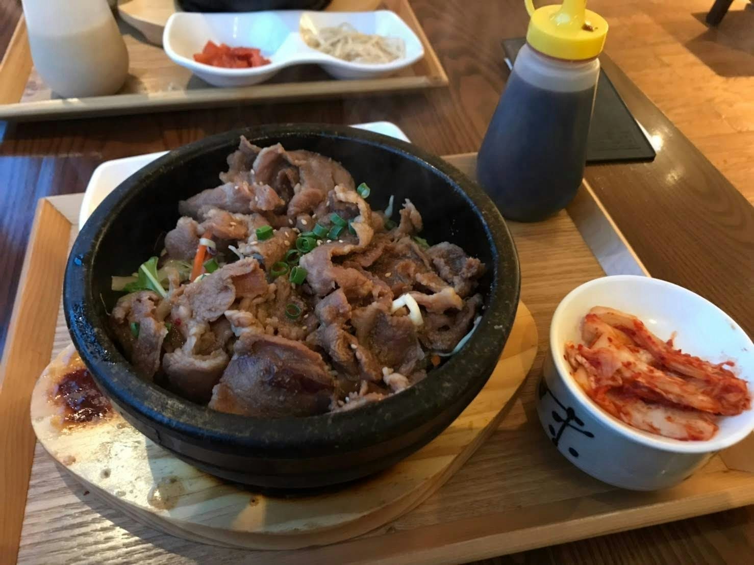 木桌上的石锅风肉菜与泡菜