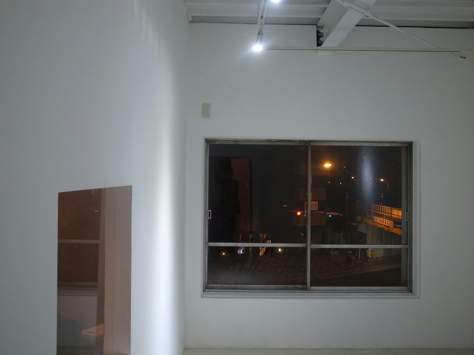 白色墙壁的房间内部，窗外夜景透入