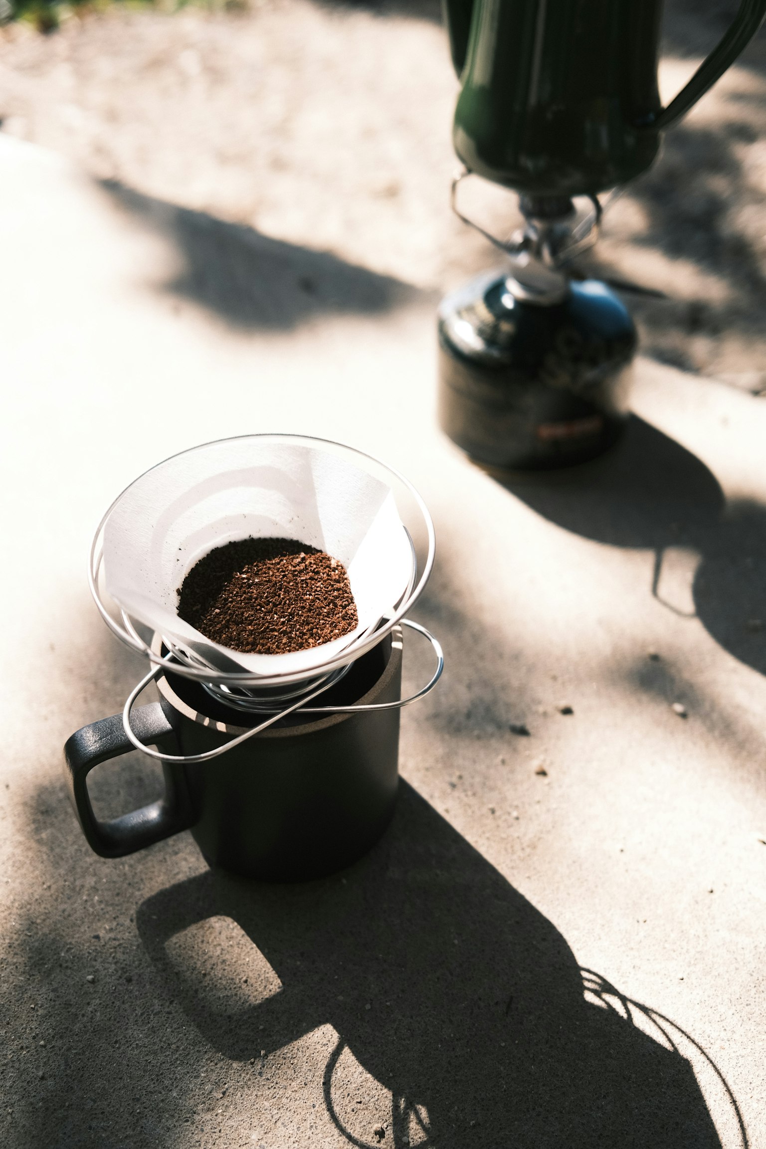 Bubuk kopi dalam saringan di atas cangkir di tempat teduh