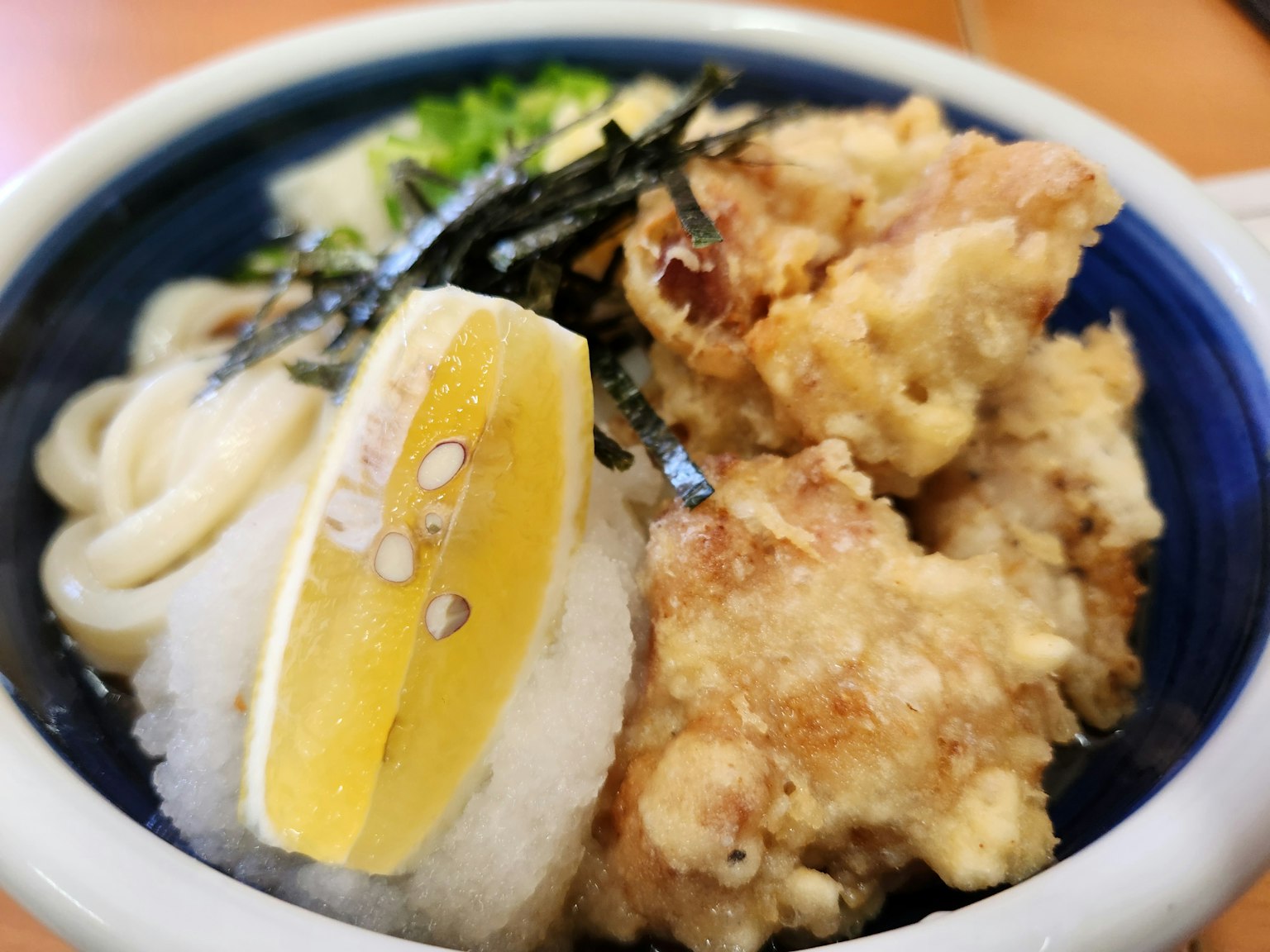 ชามอุด้งที่มีไก่ทอดและมะนาว