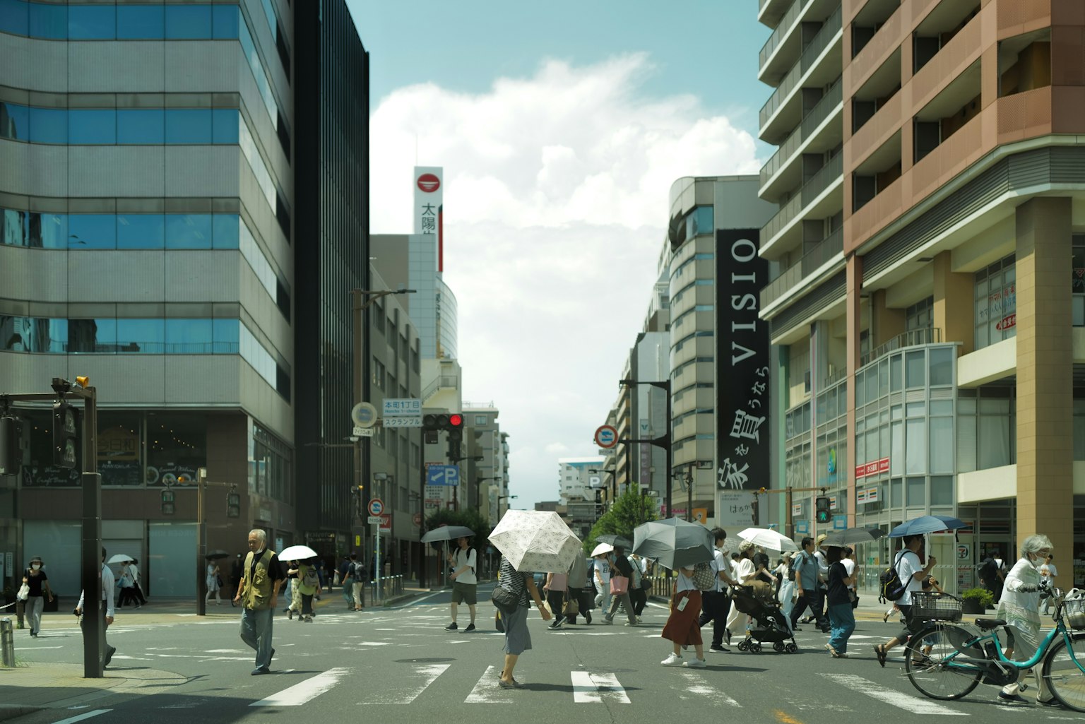 Busy intersection with people carrying umbrellas crossing the street