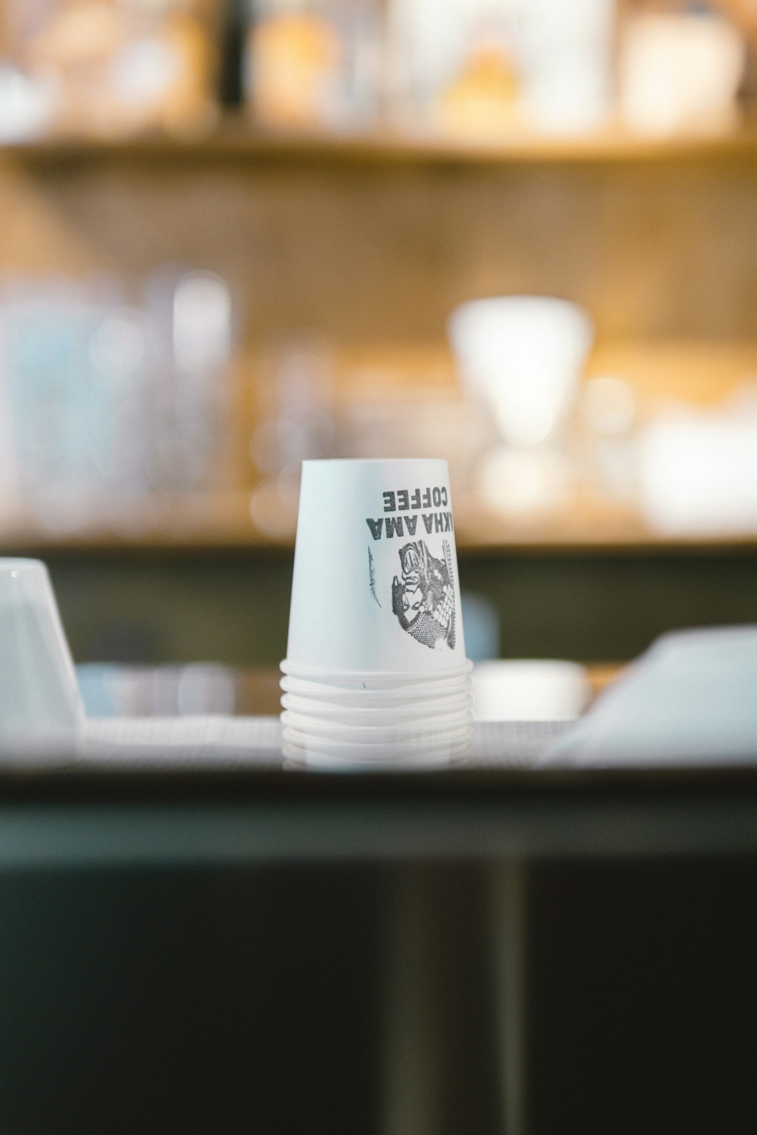 Stacked white paper cups on a café counter