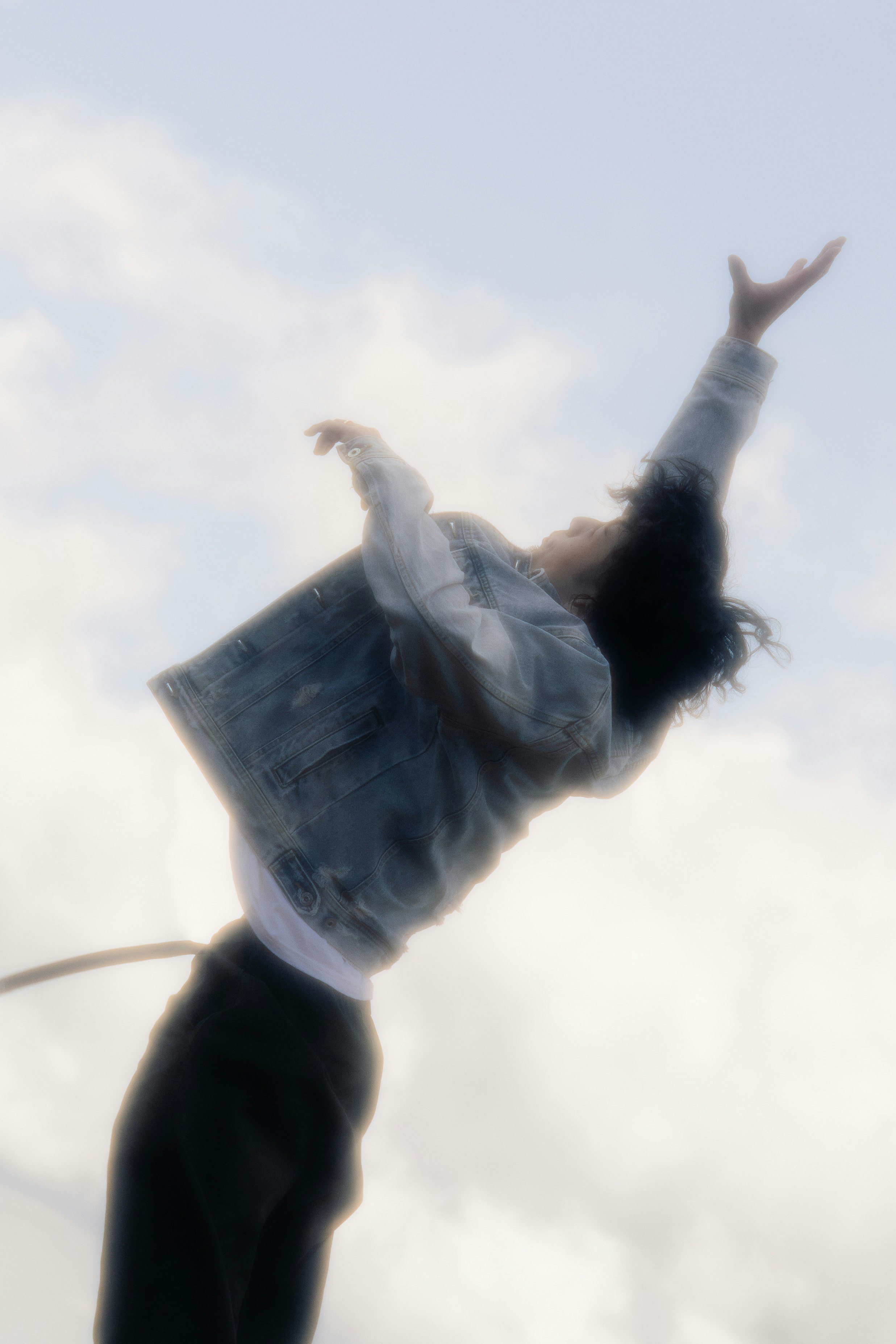 天空背景下张开双臂的人物剪影