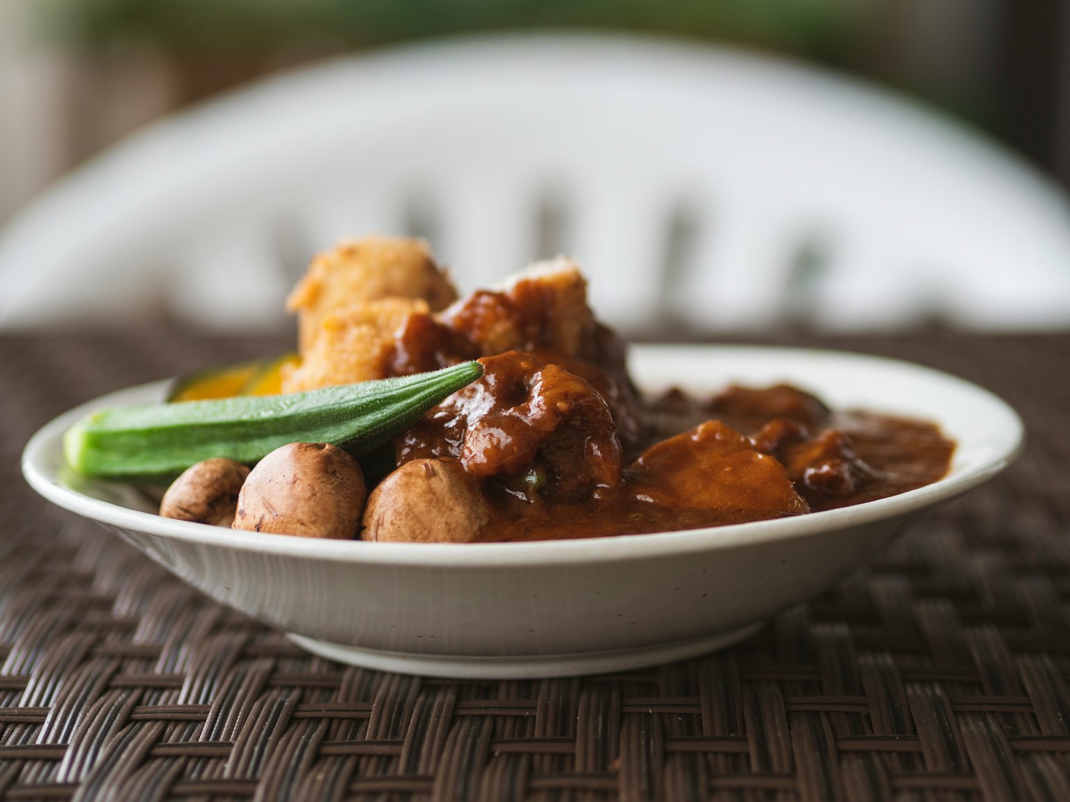 Một đĩa gà trong nước sốt với dưa chuột và nấm bên cạnh