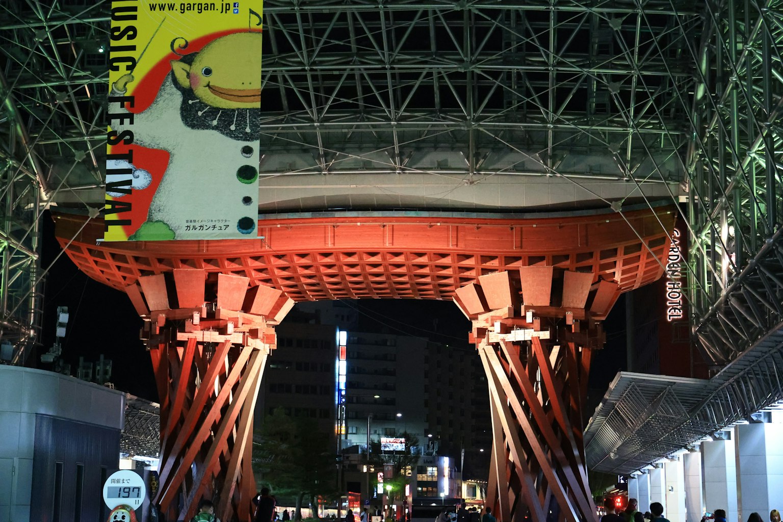 Large red supports and modern architecture at Nagoya Station at night