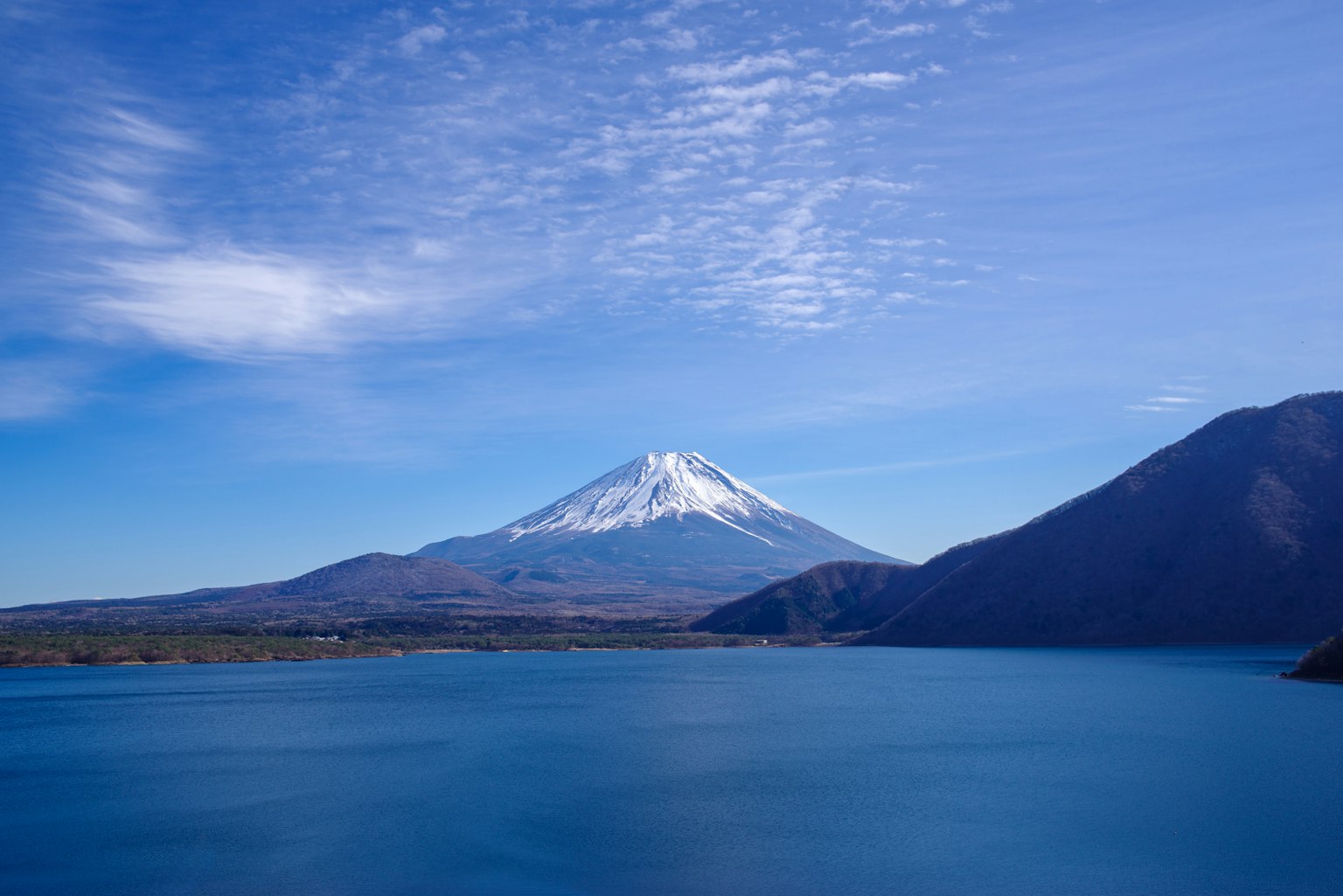 Scenic view of Mount Fuji with snow cap over blue lake