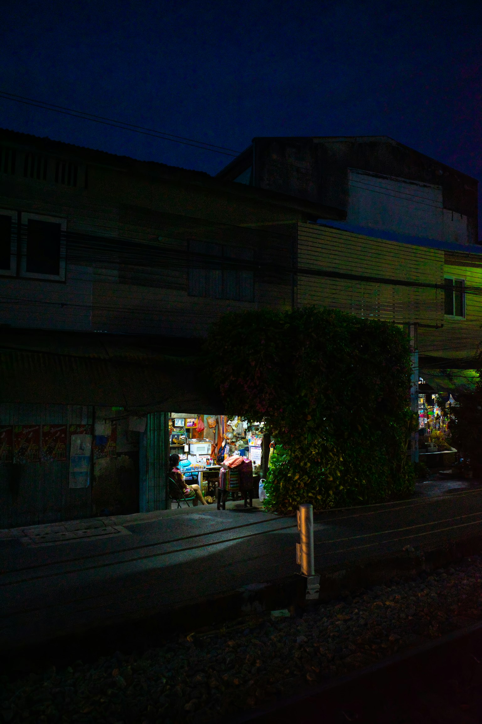 A small shop illuminated at night on a street corner