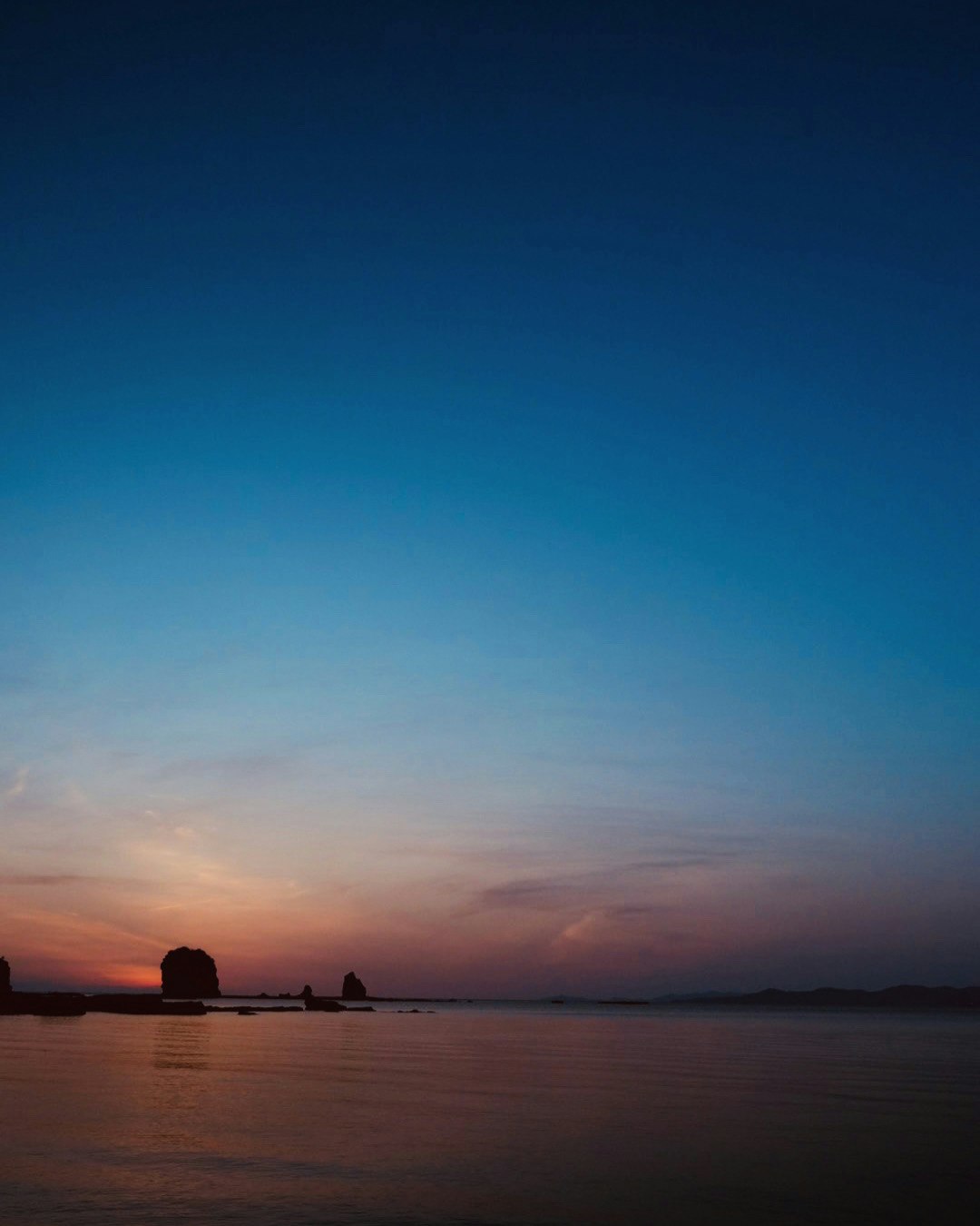 和歌山県の白良浜の夕暮れ、沈む太陽の海とシルエットの眺め