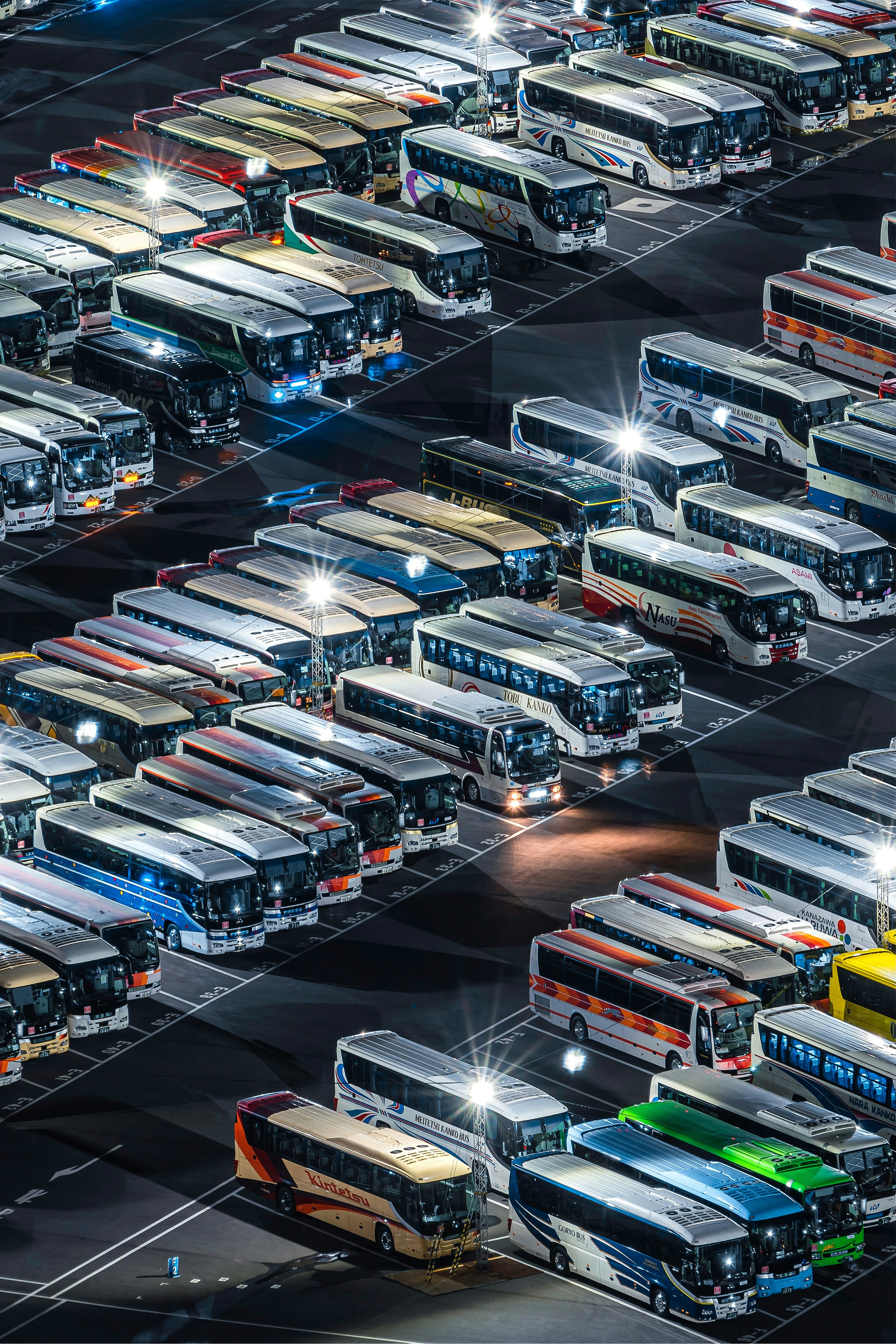 バスの列が並ぶ車両基地の夜景