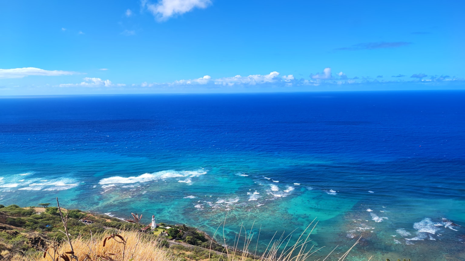 Vue expansive sur l'océan bleu et le ciel avec des vagues et des récifs coralliens visibles