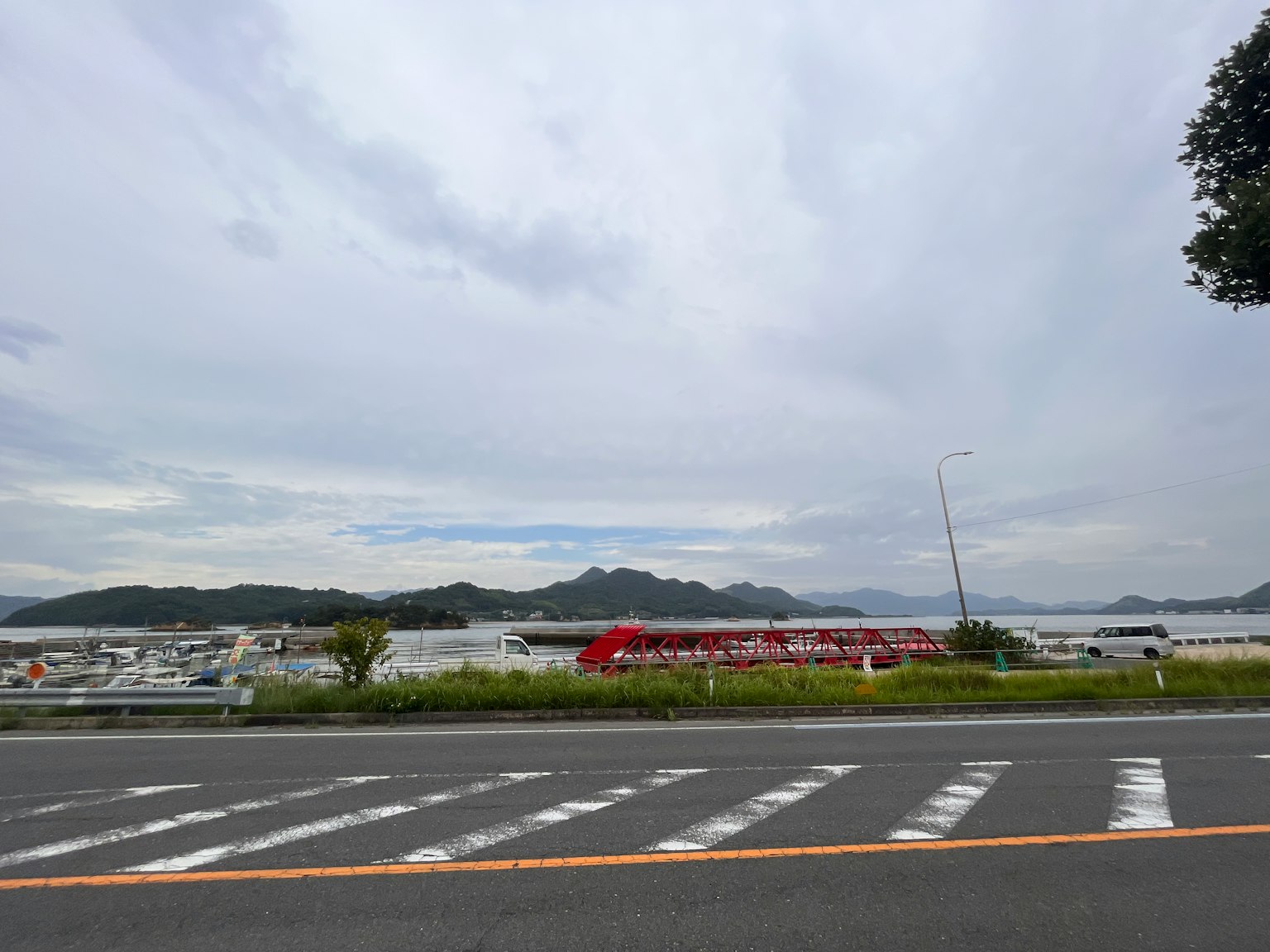 蓝天下海洋和山脉的风景 有道路和白色人行横道