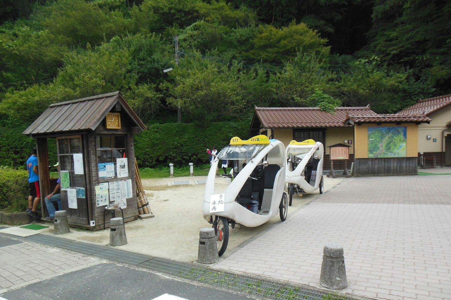 Scene featuring rickshaw bikes parked near an information board