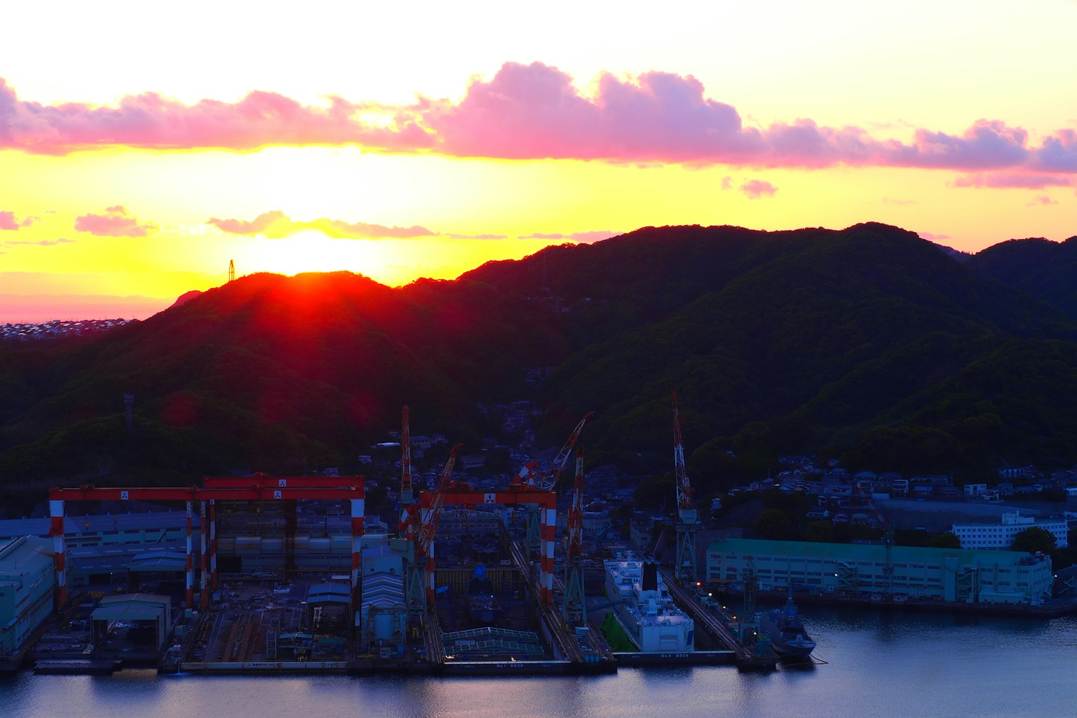 Hoàng hôn trên cảng với những ngọn núi silhouetted