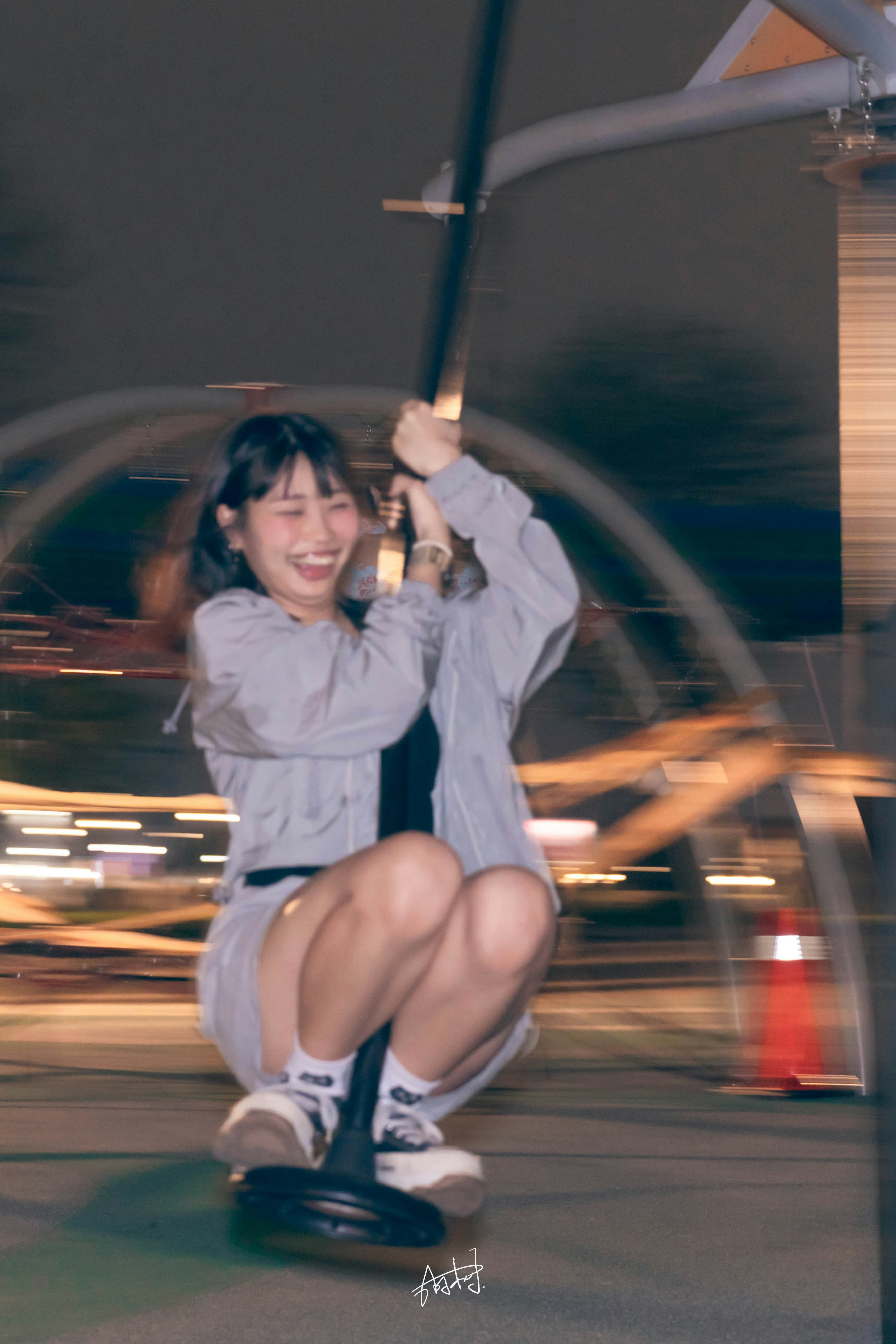 夜の公園で回転遊具に乗る笑顔の子どもたち