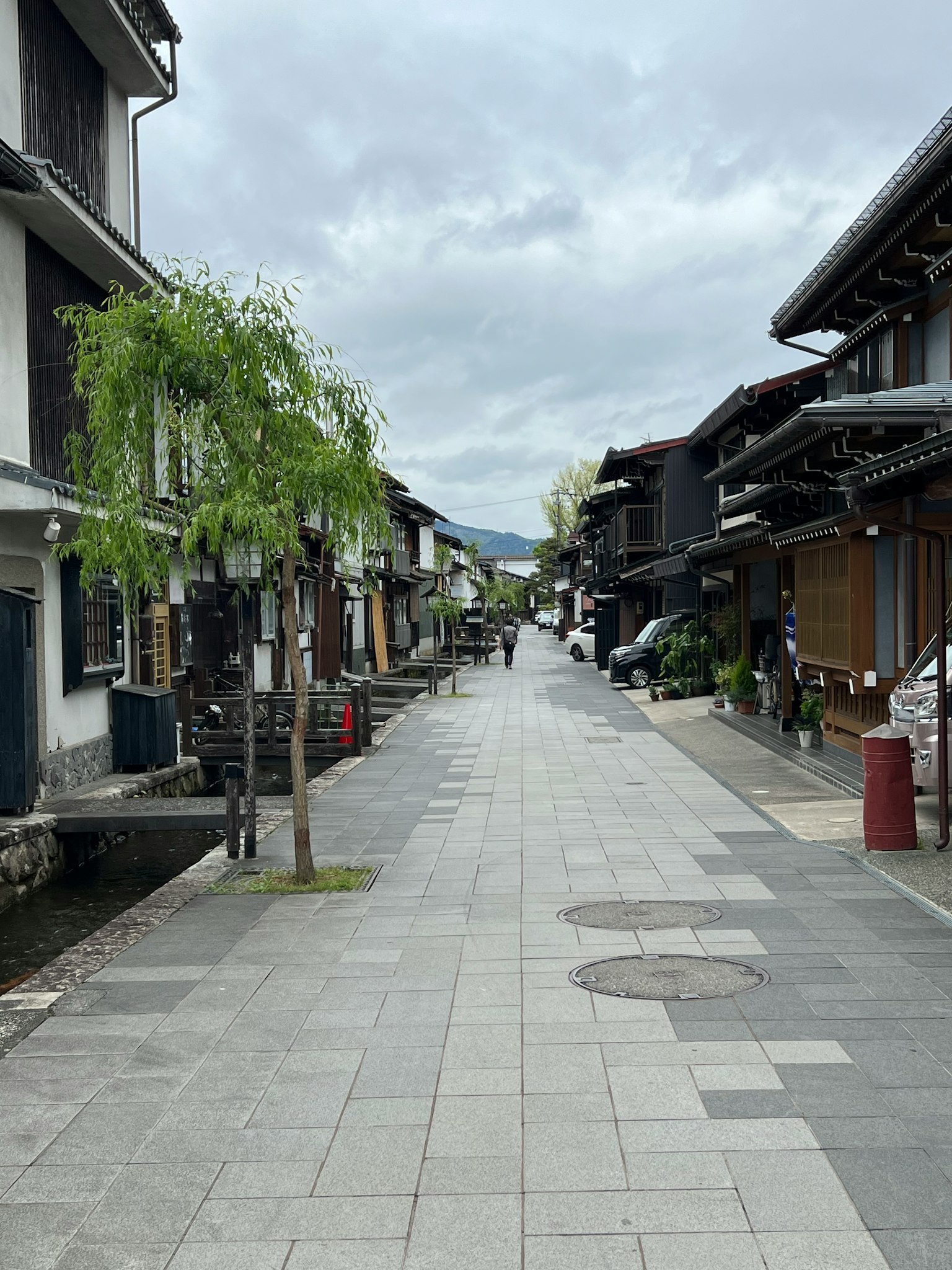 Quiet street lined with traditional buildings and green trees