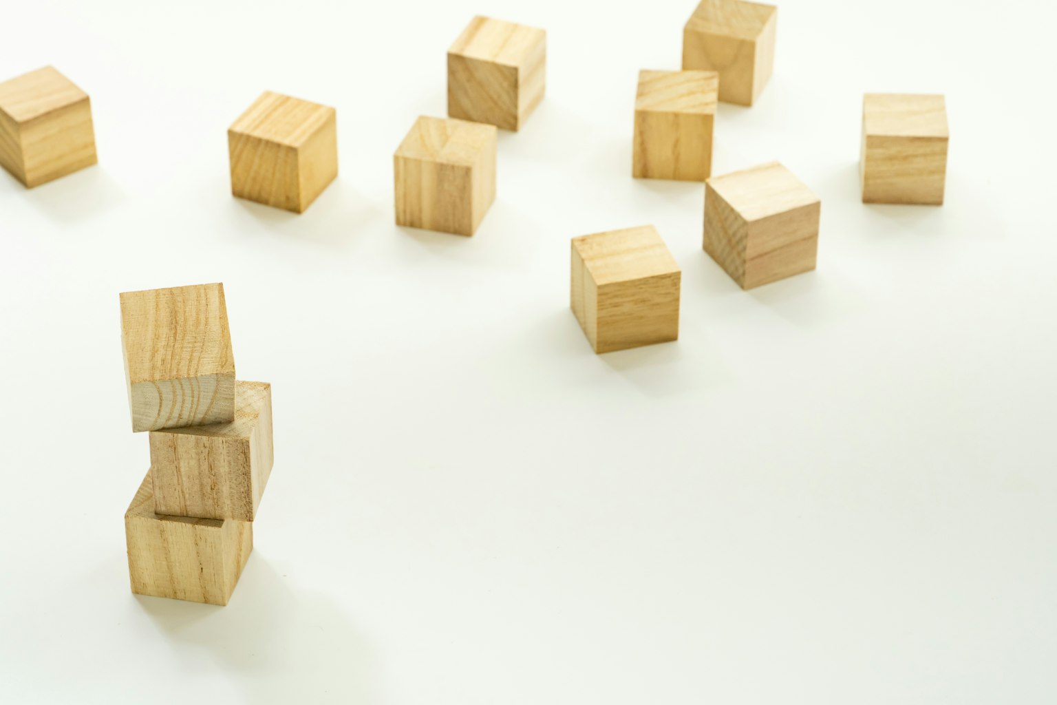 Cubes en bois éparpillés sur un fond blanc avec une pile