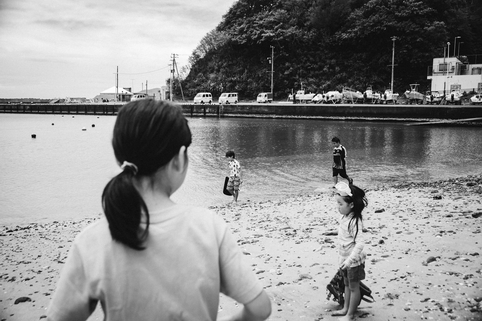 Photo en noir et blanc d'enfants jouant au bord de la mer