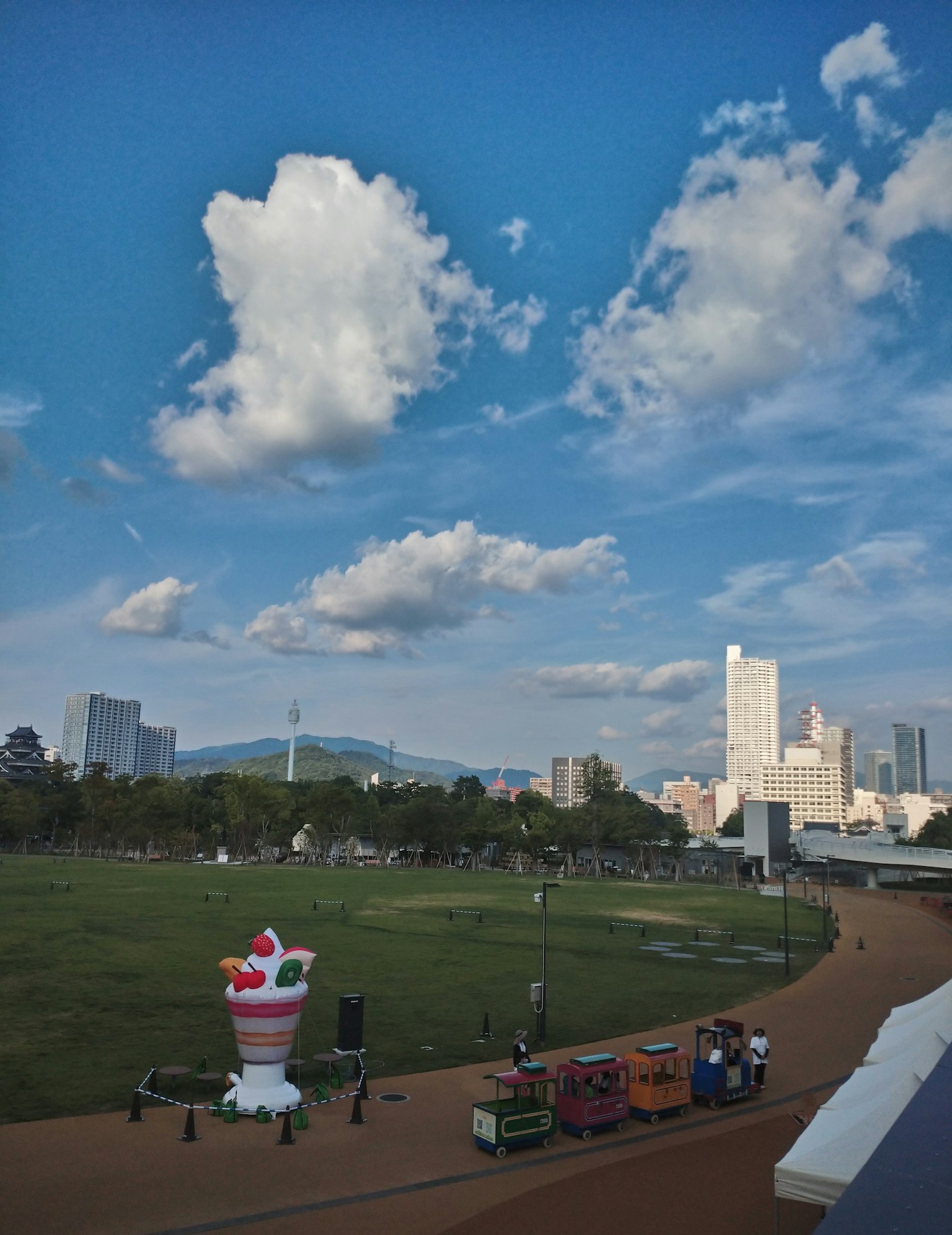 公園場景藍天和白雲大冰淇淋雕塑和色彩繽紛的食品攤位