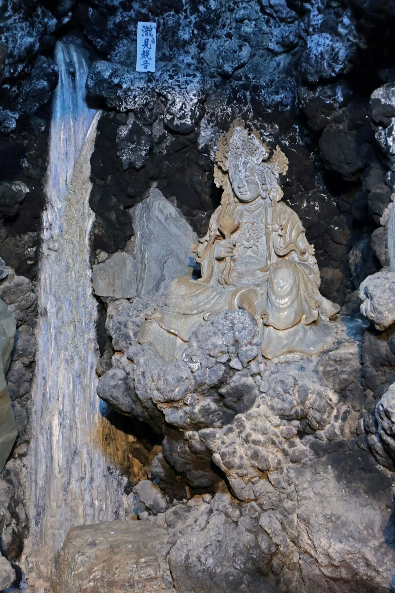 岩石环境中雕刻的神像与流动的水