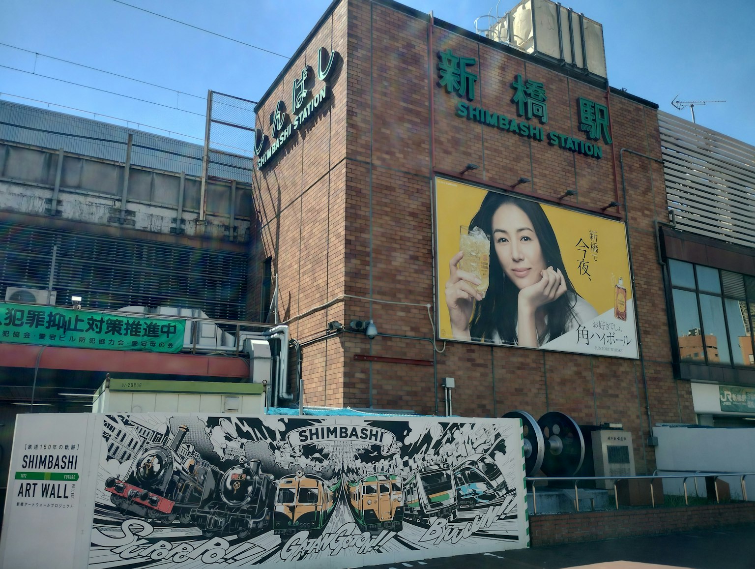 磚造建築上有一幅大型女性廣告和周圍的藝術壁畫