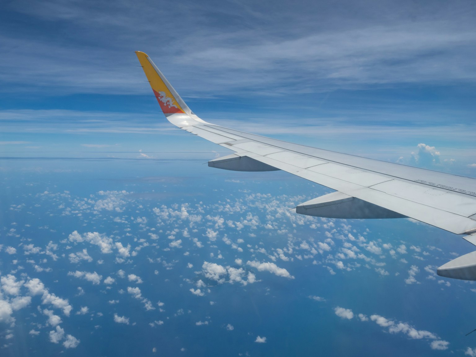 Vista dell'ala di un aereo su cielo blu e nuvole