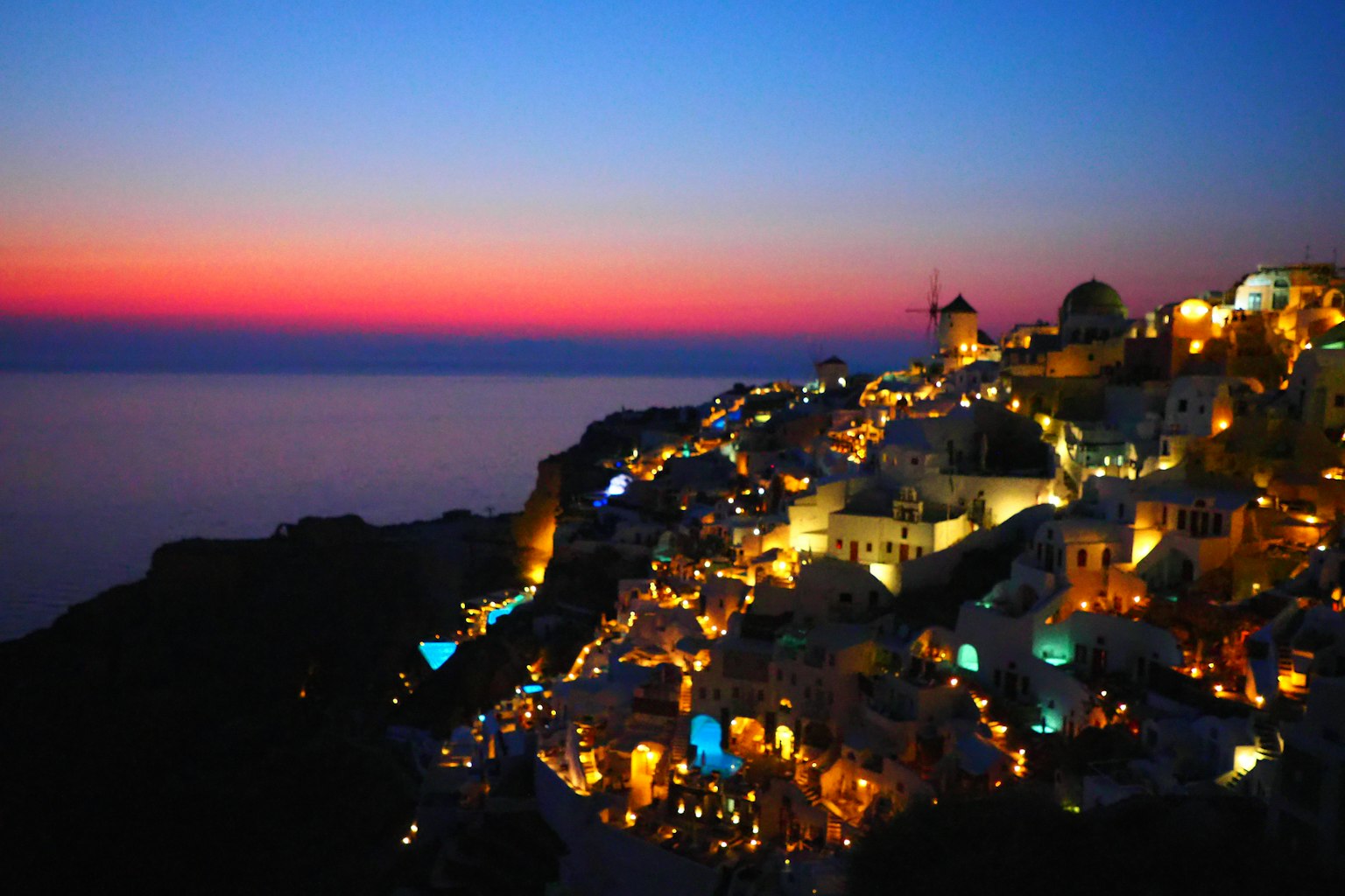 Cảnh hoàng hôn tuyệt đẹp trên đảo Santorini với những ngôi nhà được thắp sáng