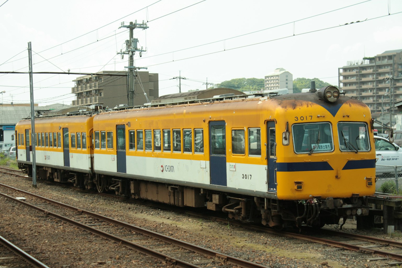 รถไฟที่มีสีเหลืองและขาวจอดอยู่ที่สถานี