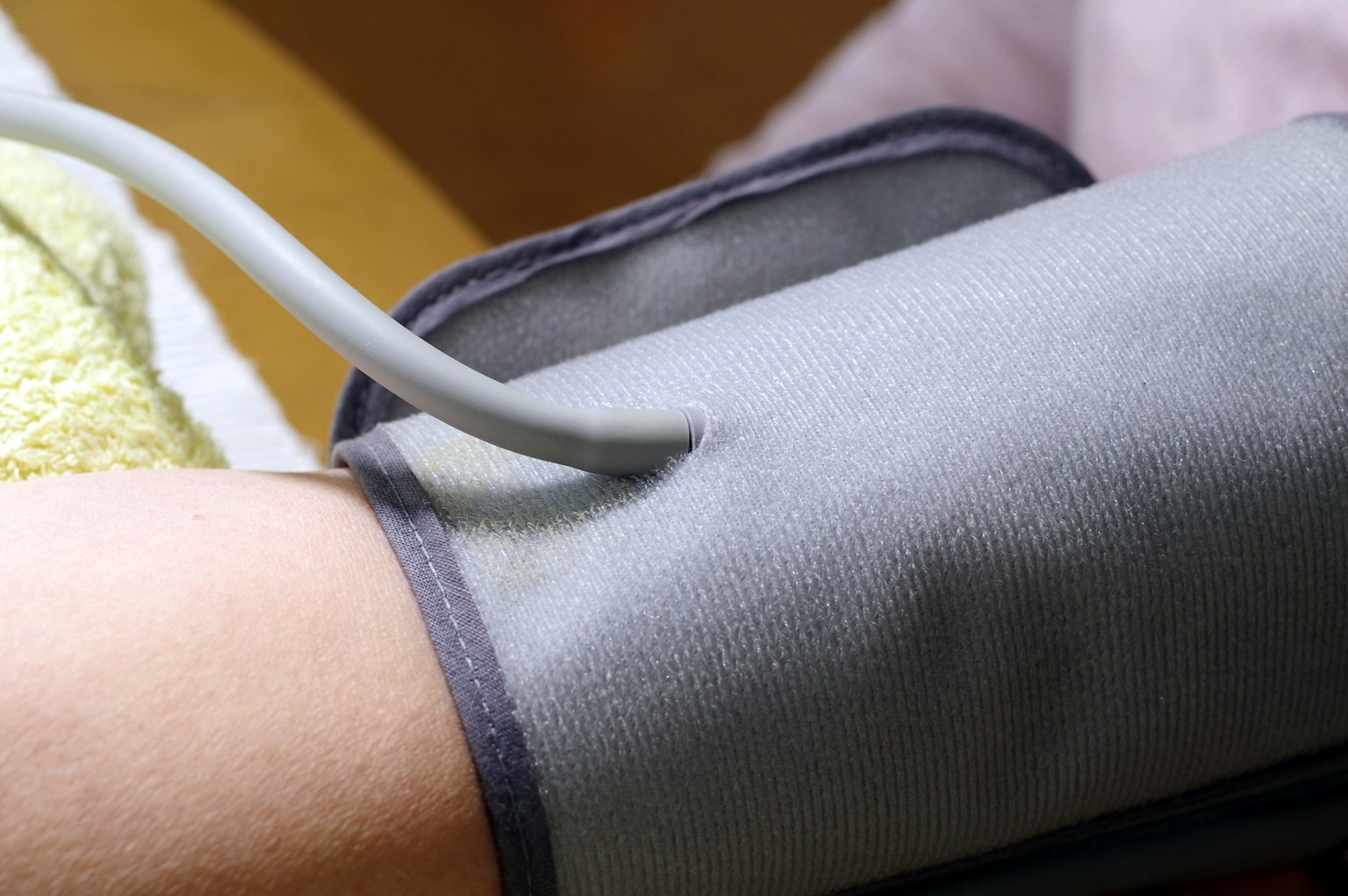 Eine Blutdruckmanschette wird an einem Arm angelegt