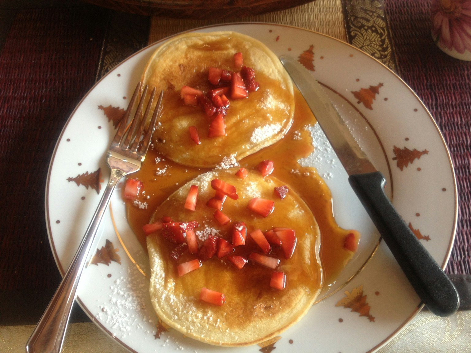 Một đĩa bánh pancake phủ dâu tây và siro cây phong