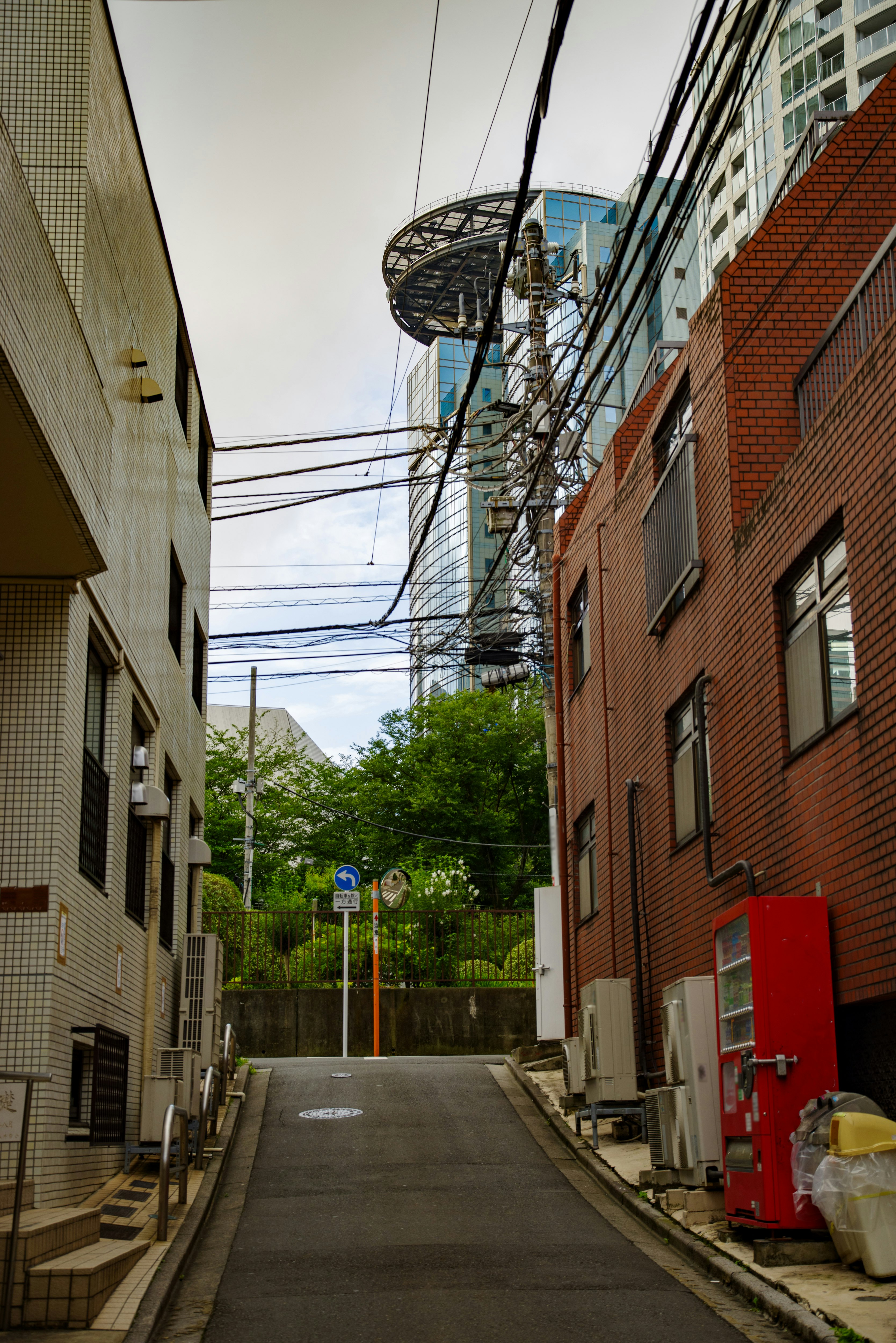 路地の電線とレンガ壁の建物が並ぶ街並み