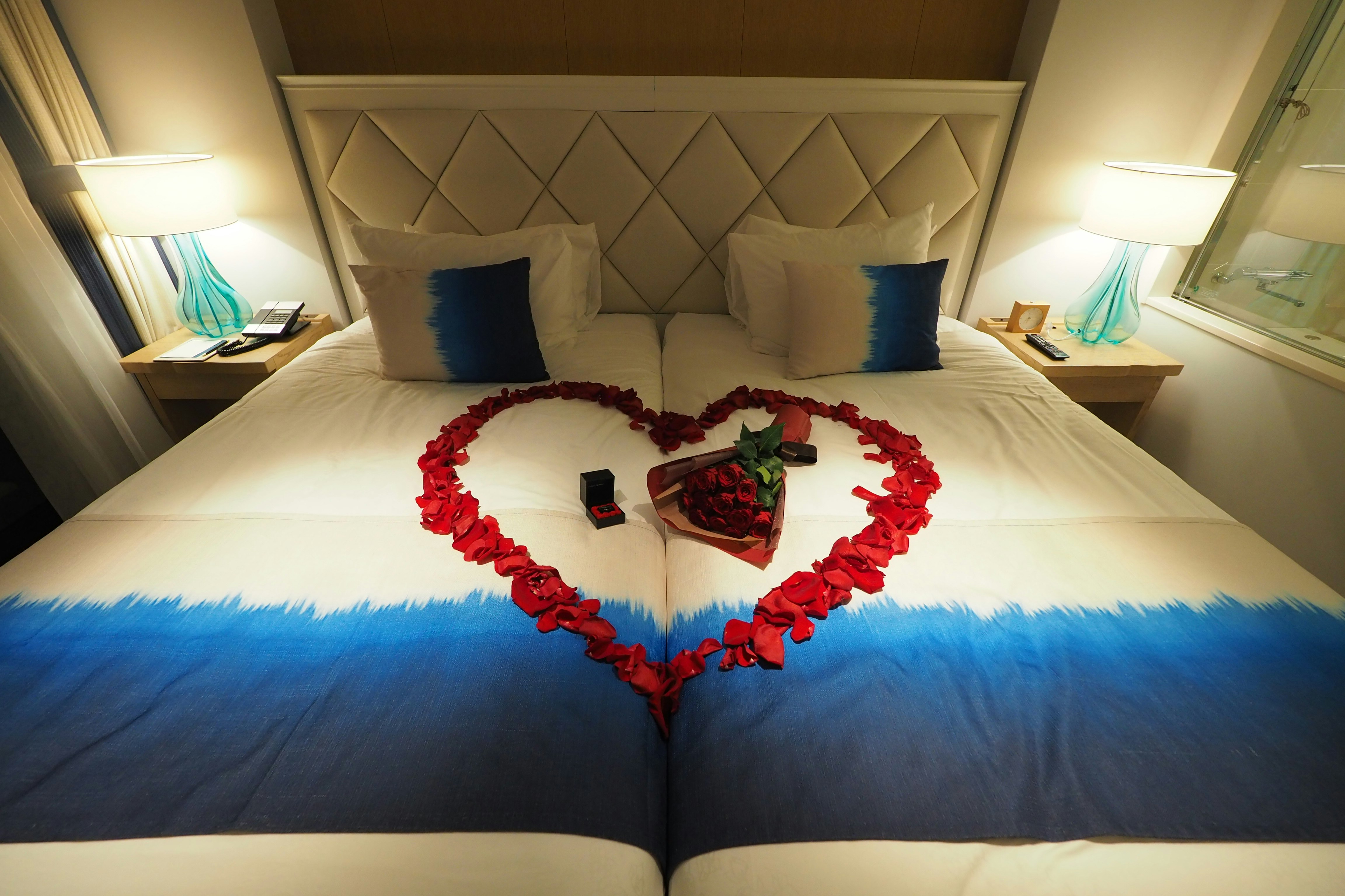 bedroom with heart-shaped flower petals and floral decoration on the bed