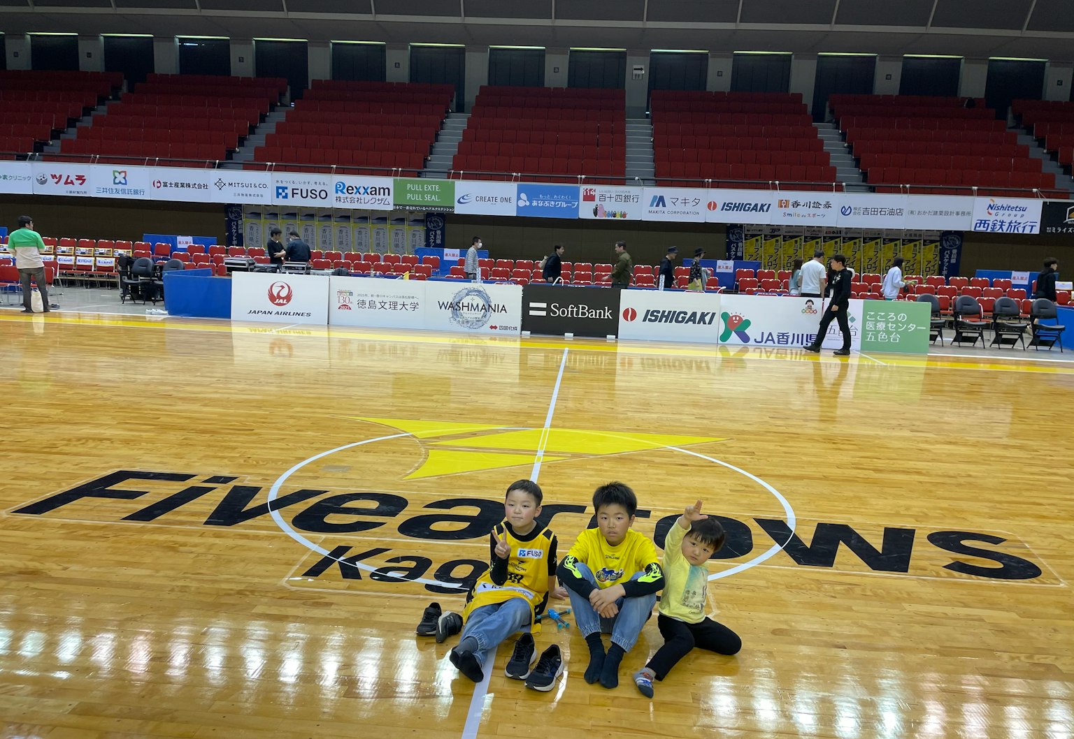 两个孩子在篮球场上与Fivearrows Kagoshima标志
