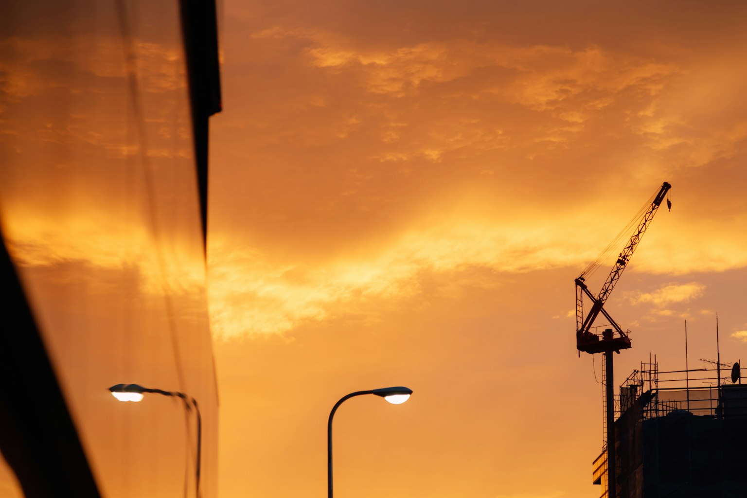 Paesaggio urbano illuminato dal tramonto con una gru