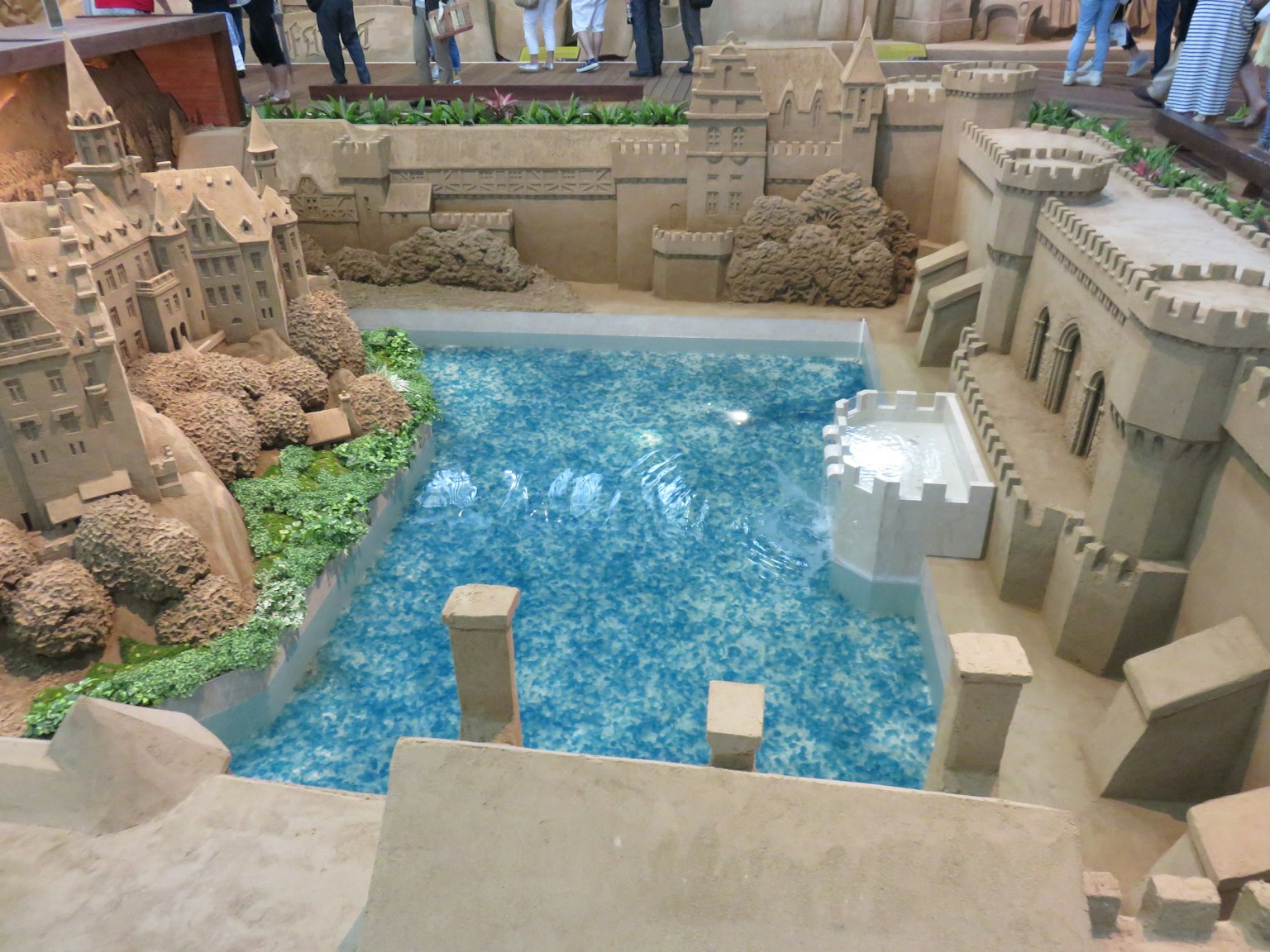 Modelo detallado de castillo de arena con un estanque azul