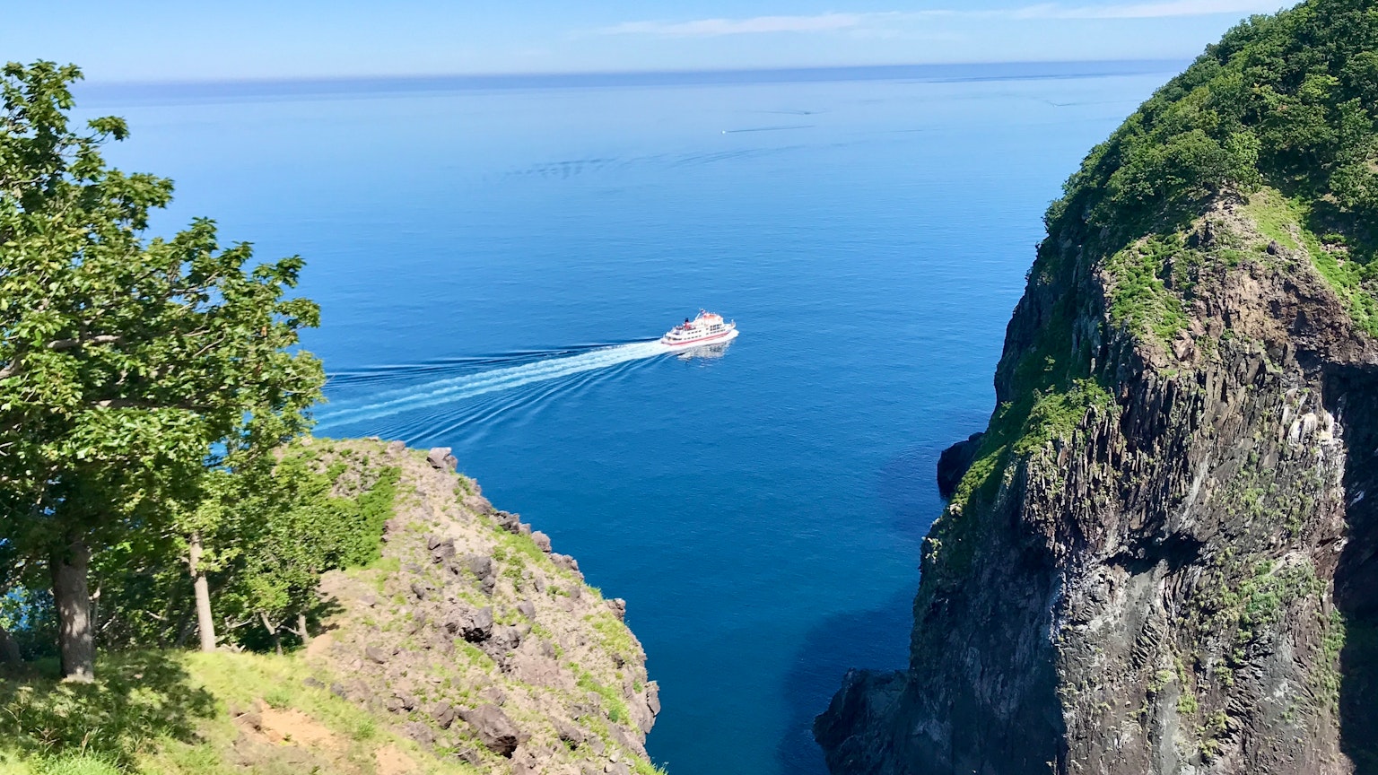 藍色水面上的小島和周圍岩壁的美麗風景