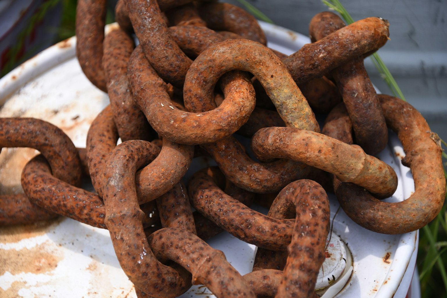 Rusty chains resting on a white bucket