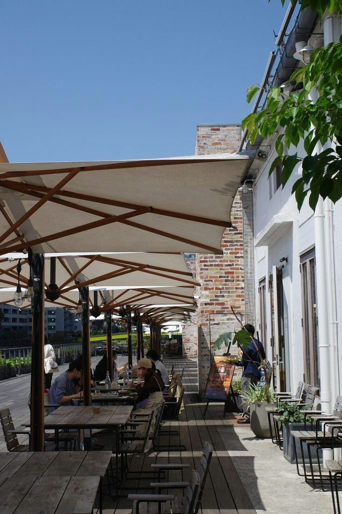 teras kafe dinding bata dengan tempat duduk luar