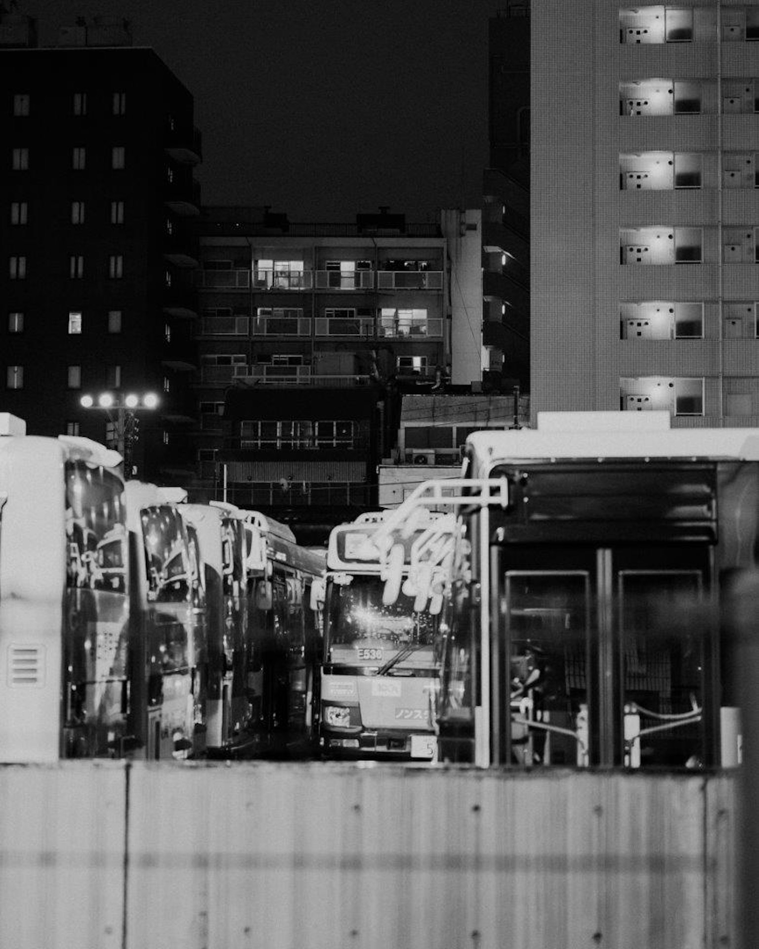 Scène urbaine nocturne avec des bus garés à un arrêt de bus