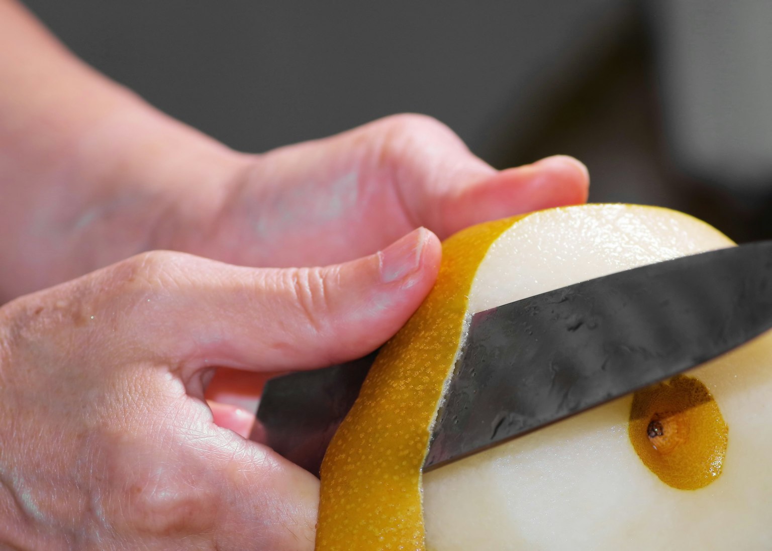 Primer plano de manos pelando una fruta