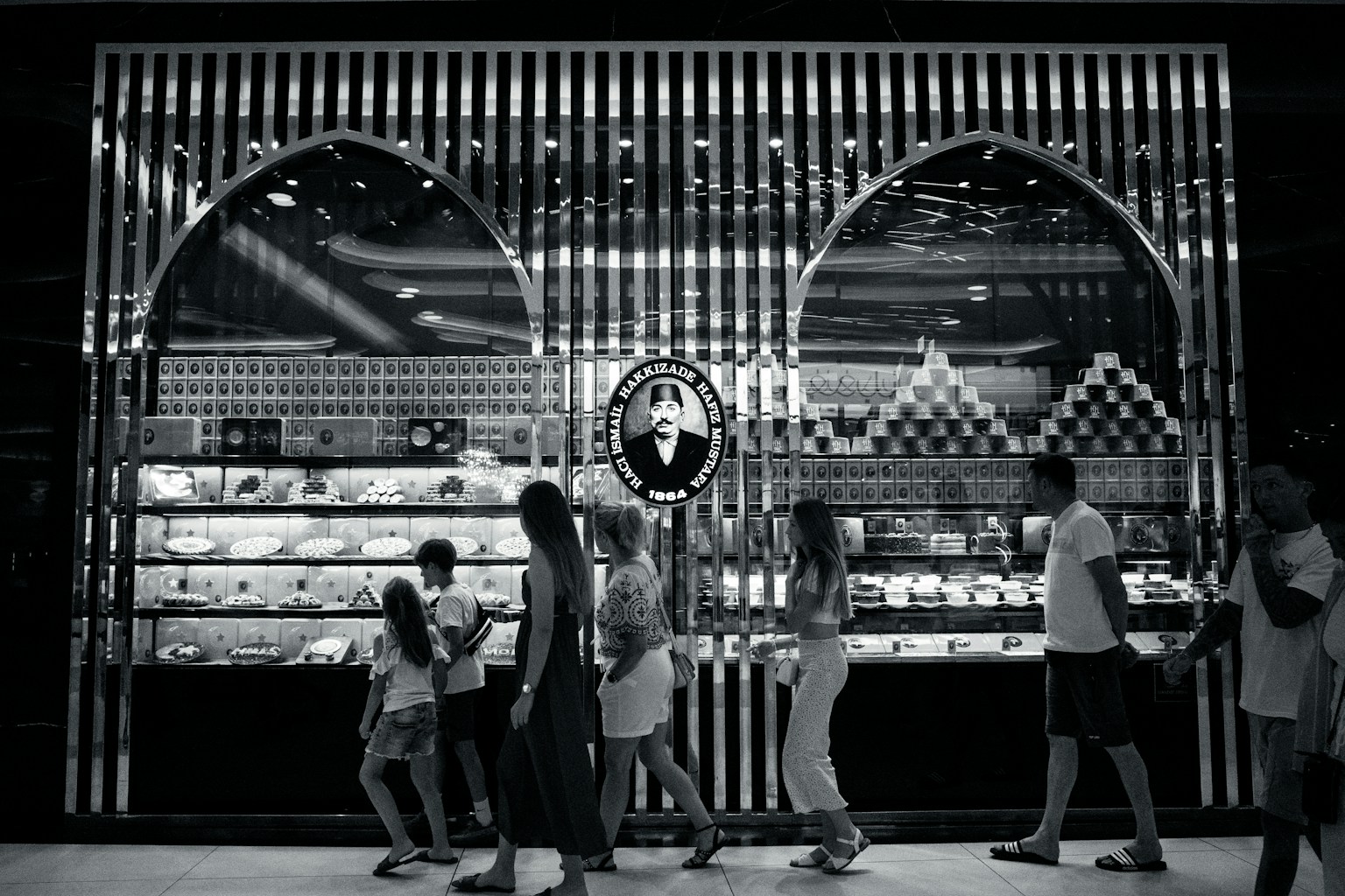 Etalase hitam putih dengan produk yang ditampilkan dan antrean orang