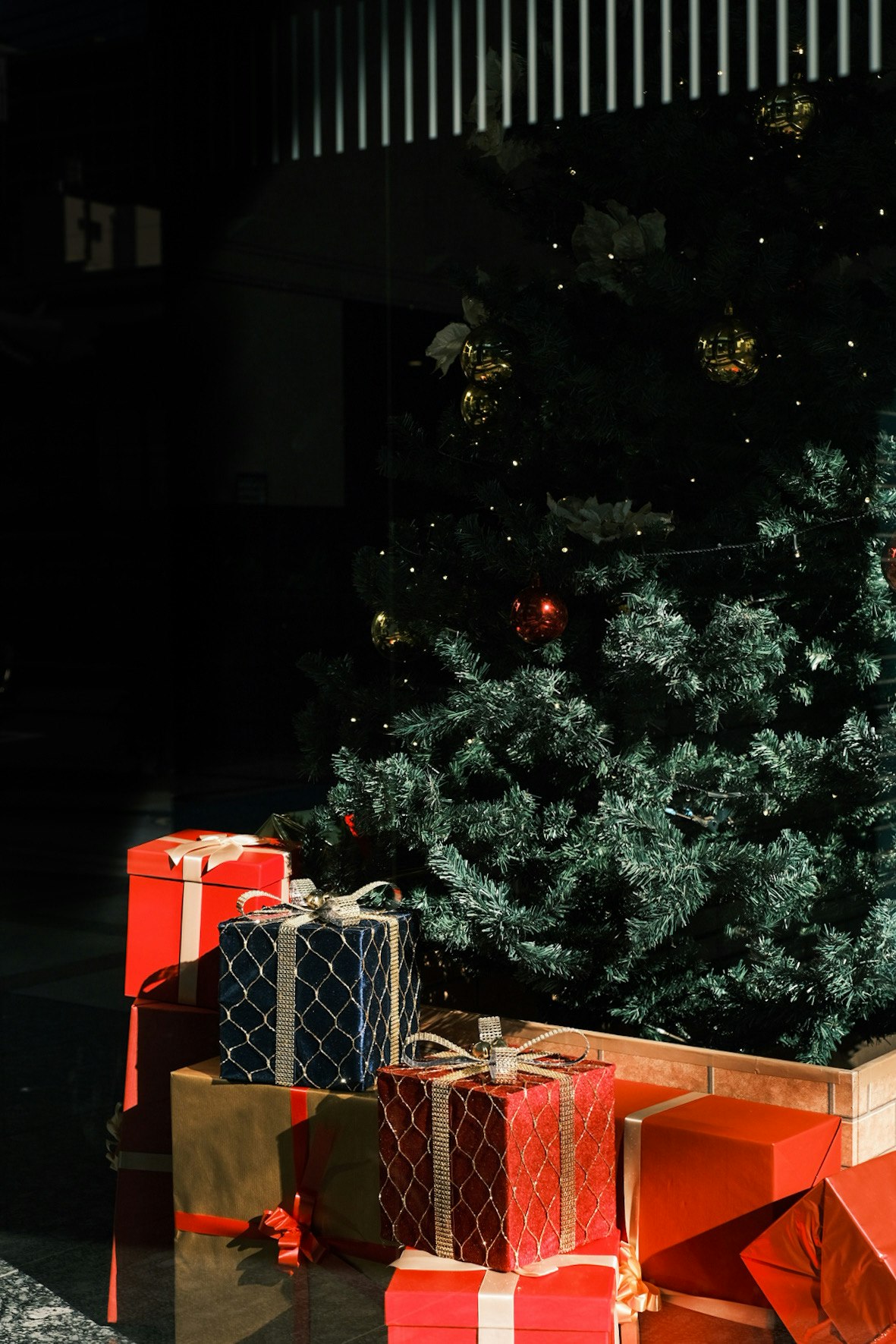 Kotak hadiah Natal berderet di depan pintu rumah pada malam hari