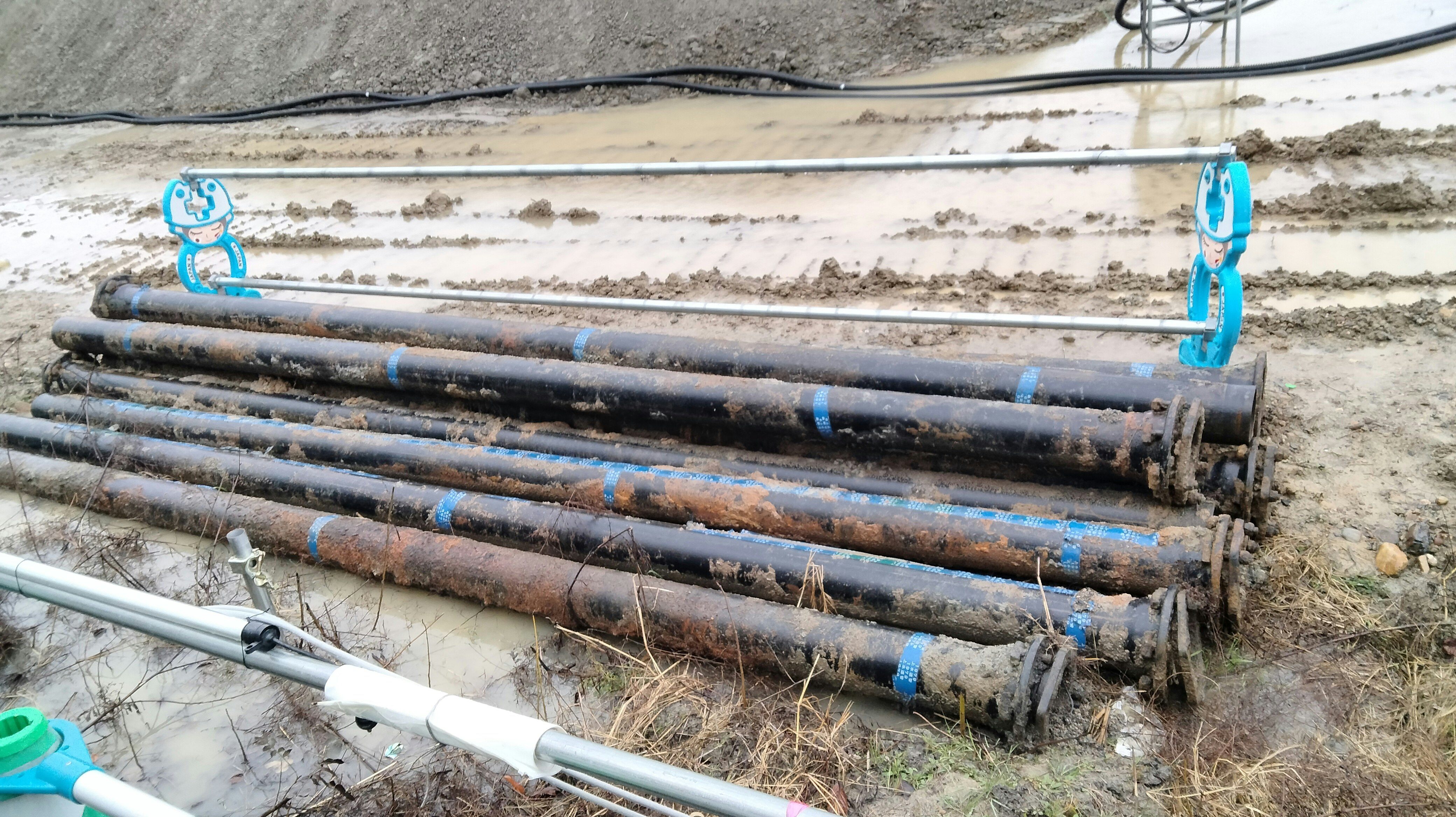 Baustelle mit am Boden verlegten Rohren und Ventilen