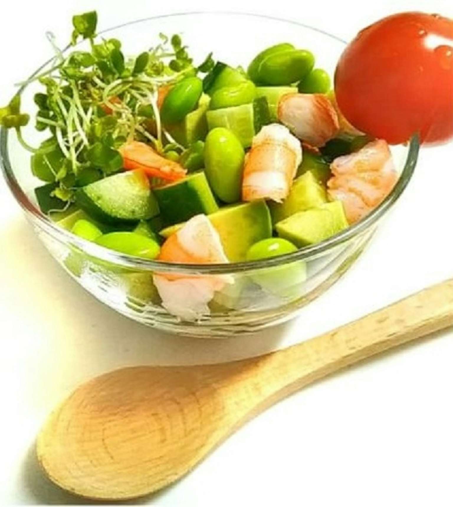 Frischer Garnelen- und Gemüsesalat in einer klaren Schüssel mit einem Holzlöffel