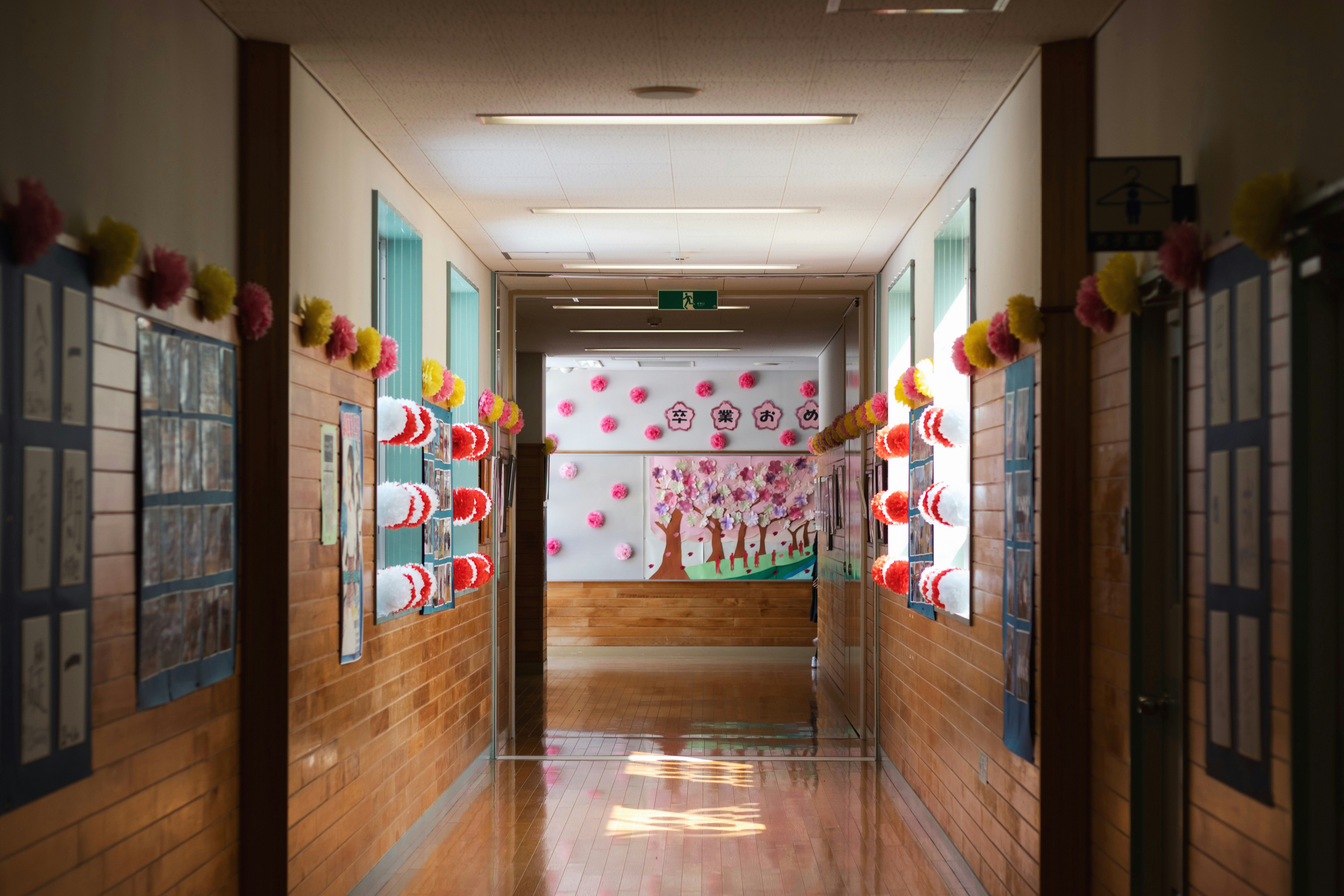廊下の壁に飾られたカラフルな装飾と掲示物のある学校の内観