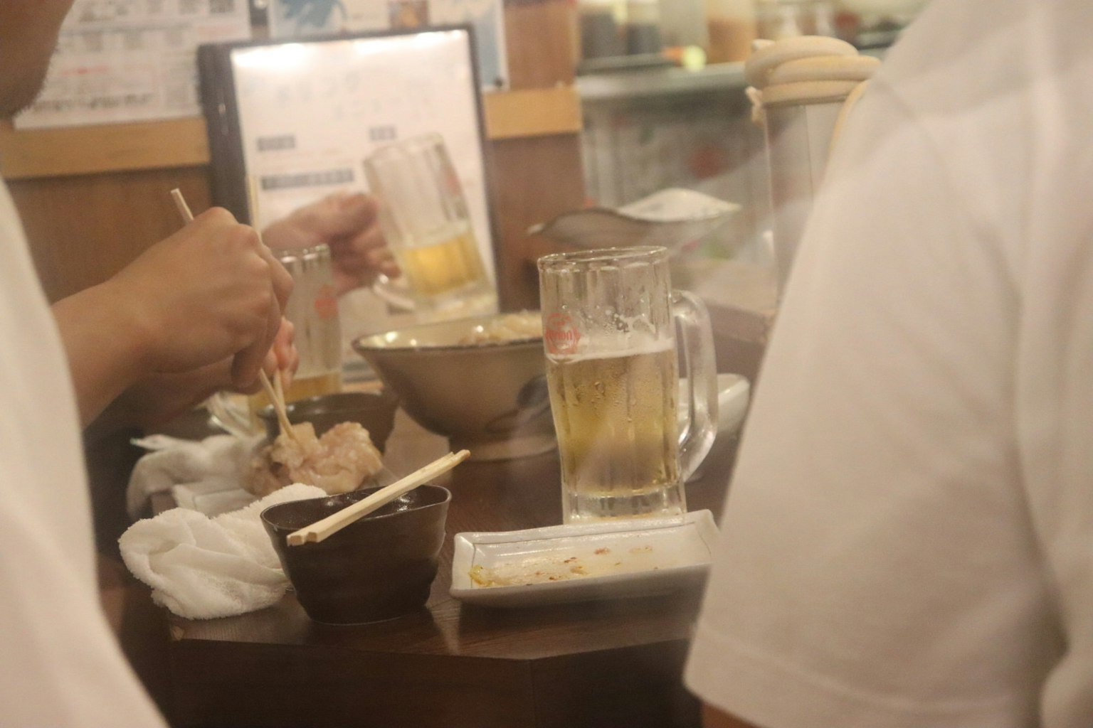 Dining scene at an izakaya with beer and food