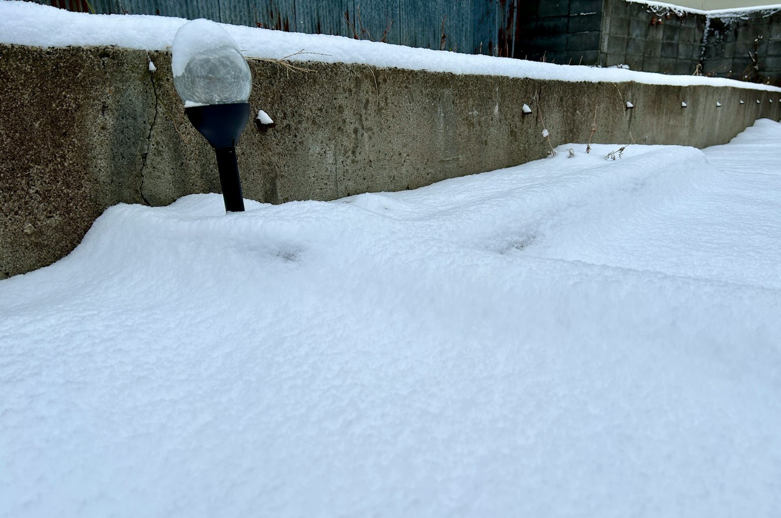 Landschaft mit schneebedecktem Boden und einer Straßenlaterne