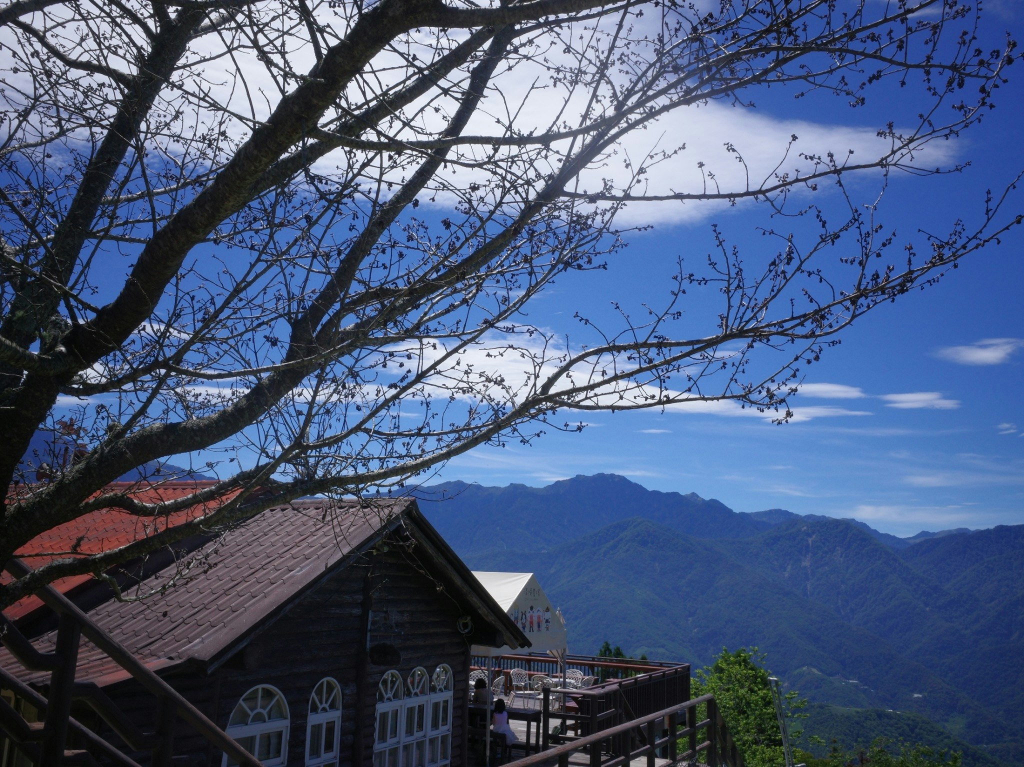 清境農場の山並みを望む木造の建物と青空