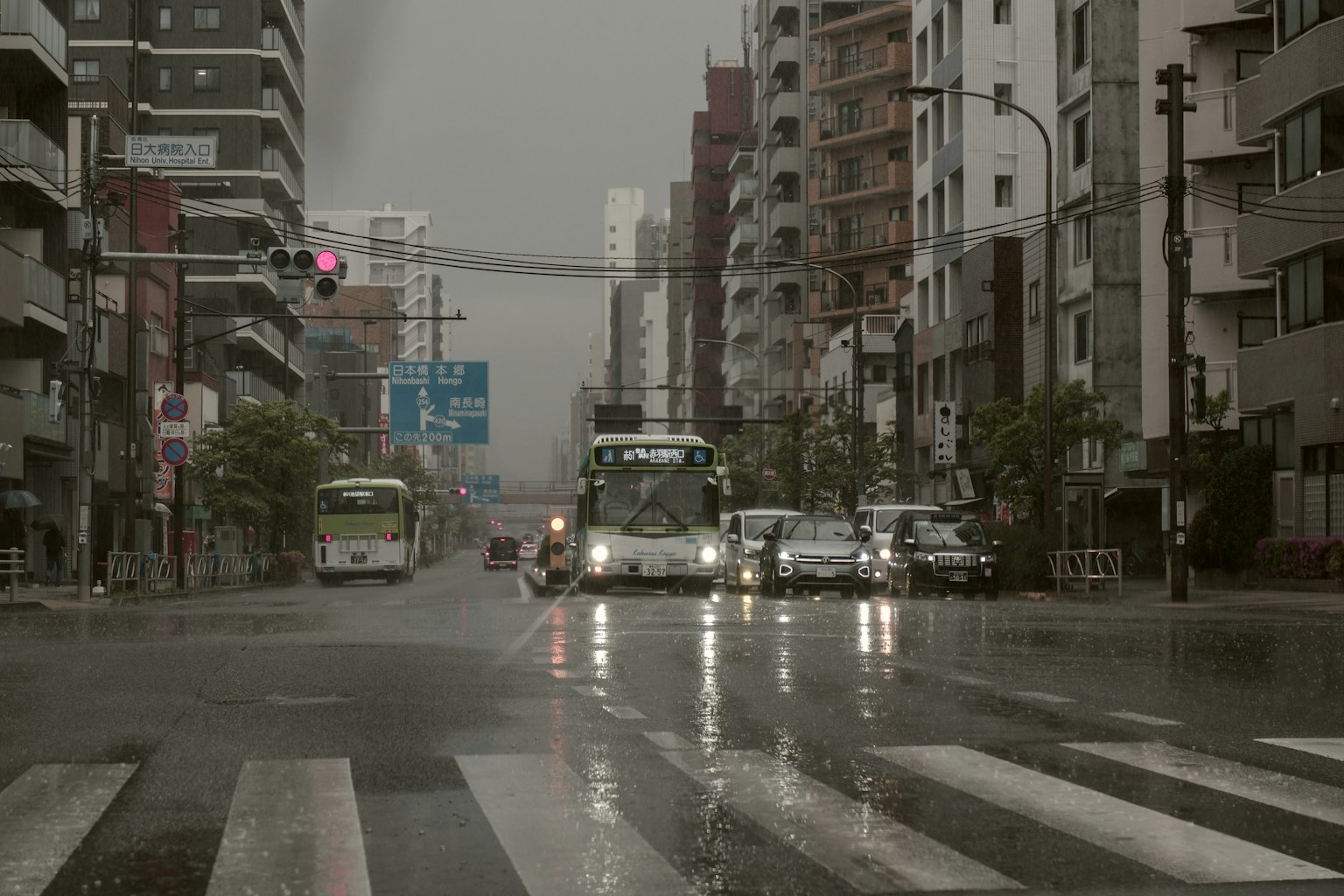 在雨中穿过城市交叉口的公交车和汽车