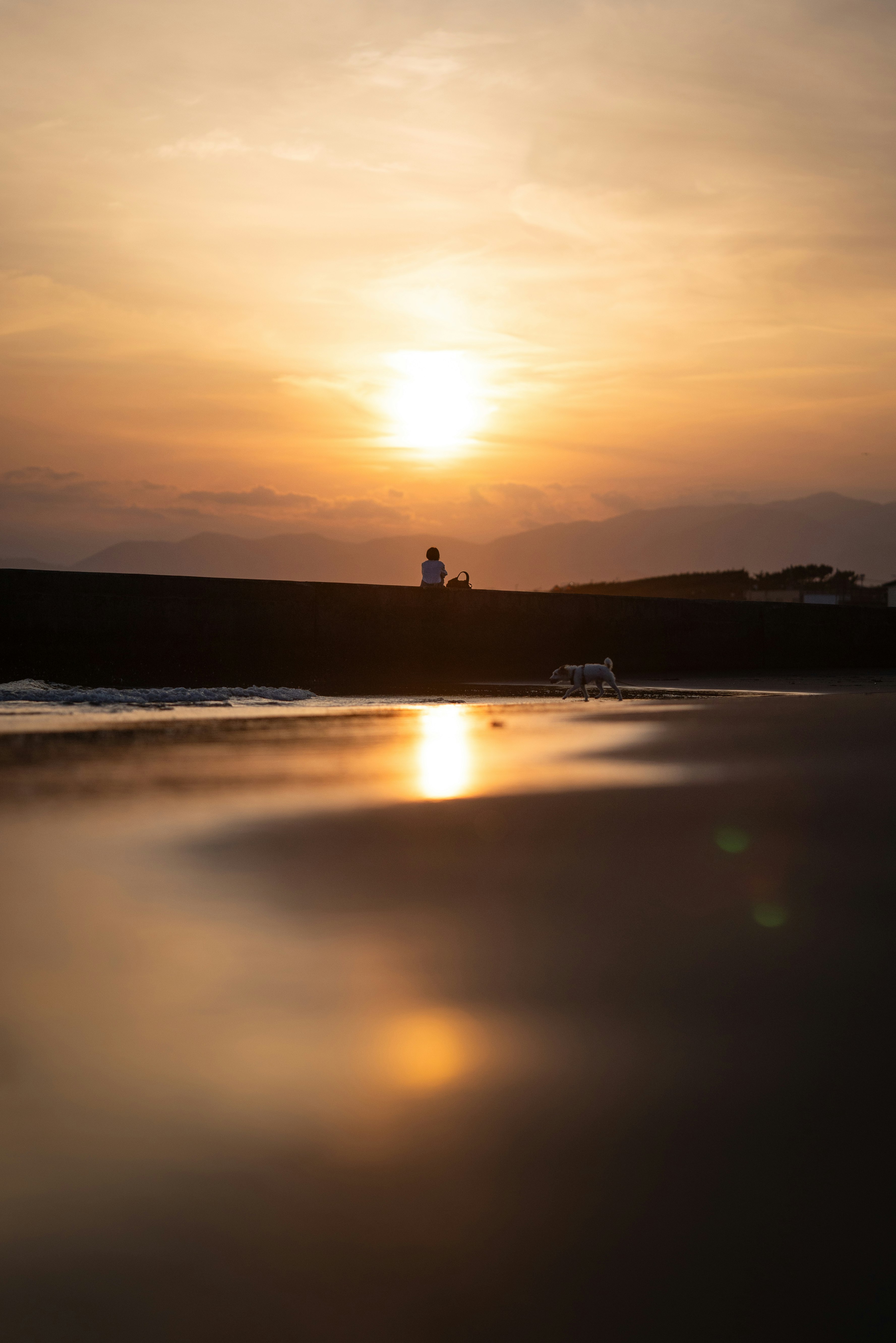 江ノ島の夕日を一人で眺める海辺の風景